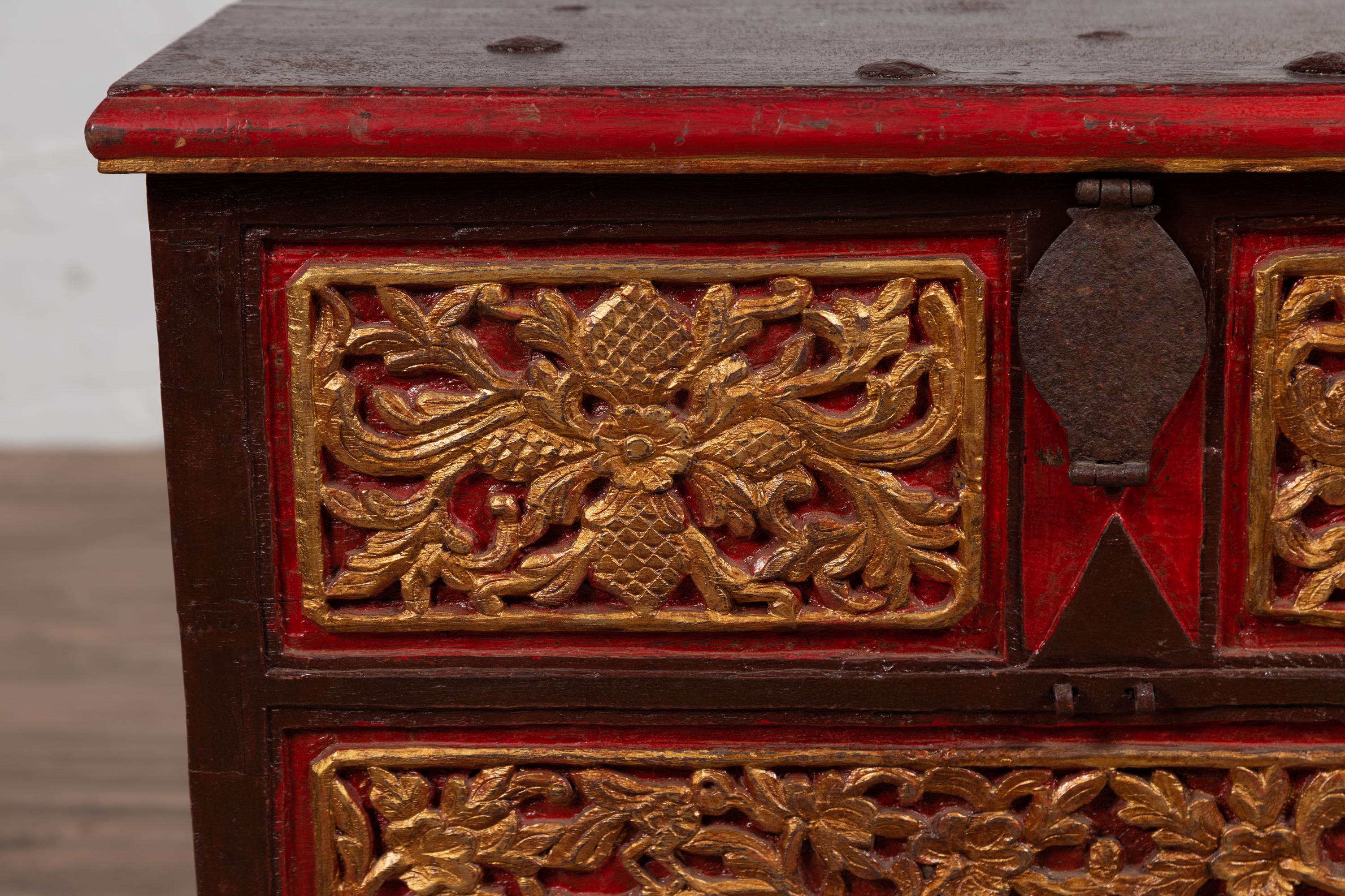 Peint à la main Coffre à couvertures antique en bois sculpté à la main de Madura avec des accents rouges, Brown et dorés en vente