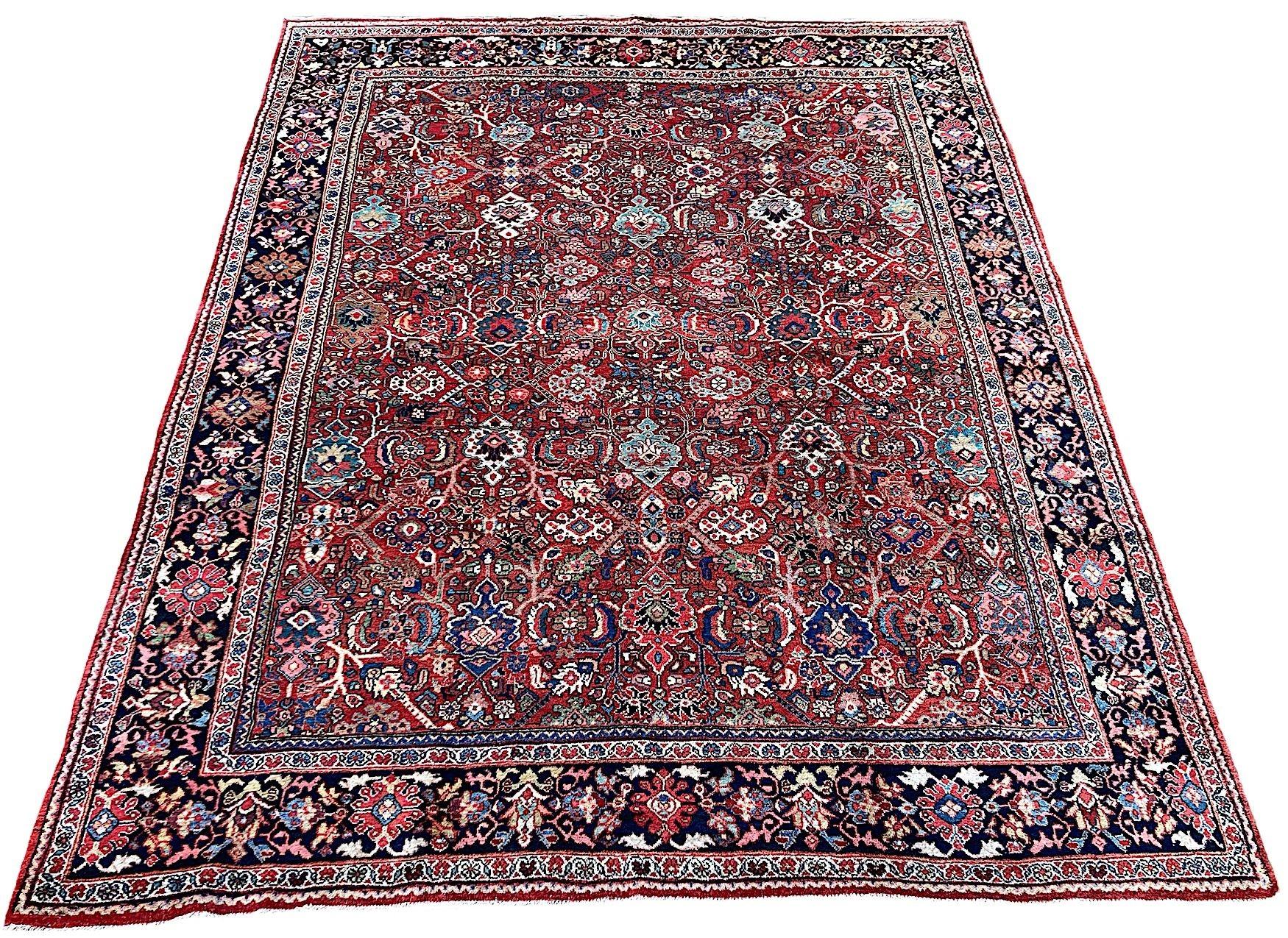 Un bellissimo tappeto Mahal antico, tessuto a mano nel 1900 circa. Il tappeto presenta un ricercato disegno all over di grandi palmette e teste di fiori su un ricco campo di terracotta circondato da un bordo indaco. Favolosi colori secondari di blu,