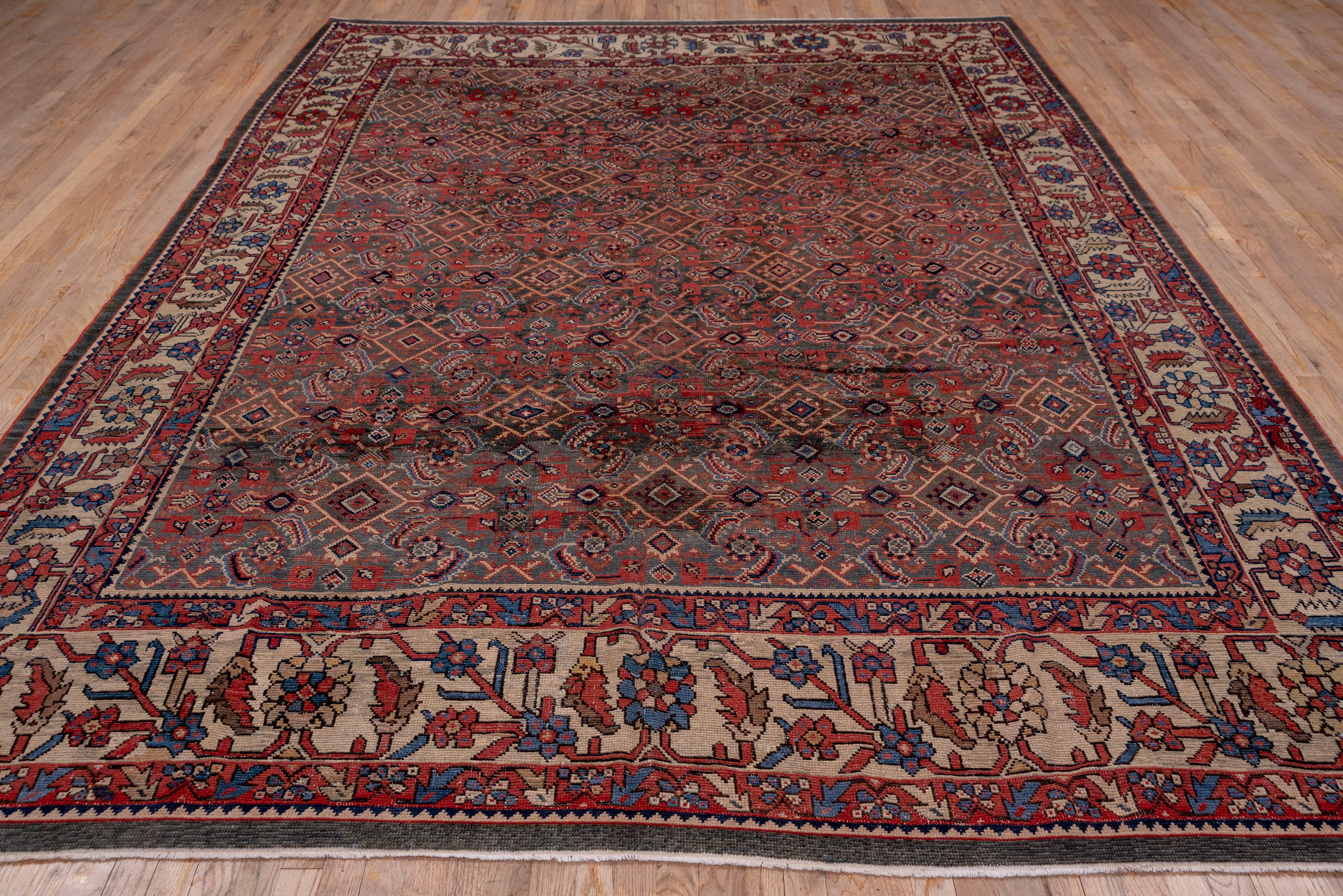 An ivory detailed allover Herati design fills the green field of this attractive west Persian rural carpet. The ivory main border employs the triple posy 