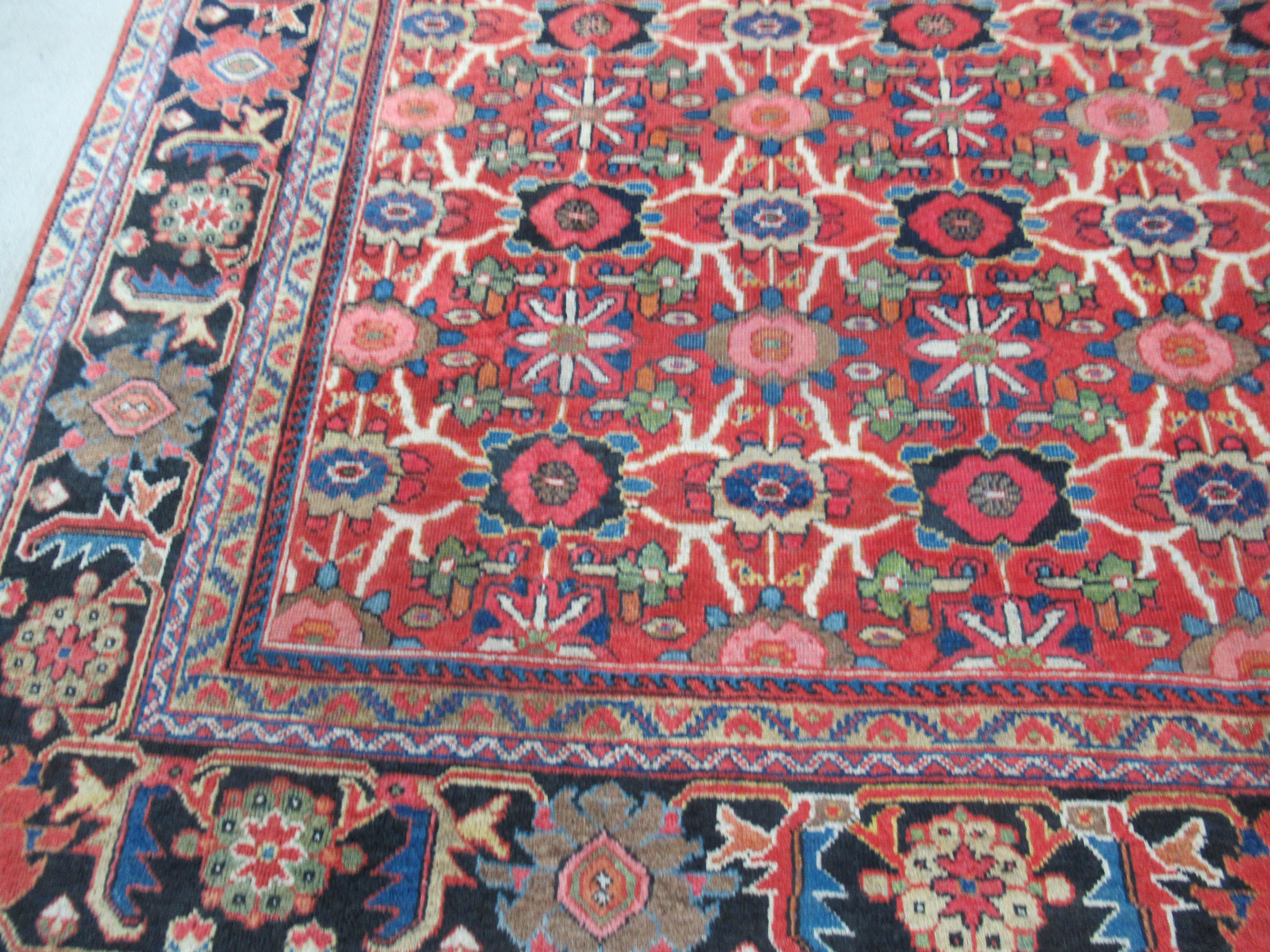 Antique Mahal carpet of large size, with all over mina khani (many flowers) design.

This outstanding large size Mahal carpet has an all over floral design on a soft red ground. The carpet is framed with a bold border on a dark indigo blue