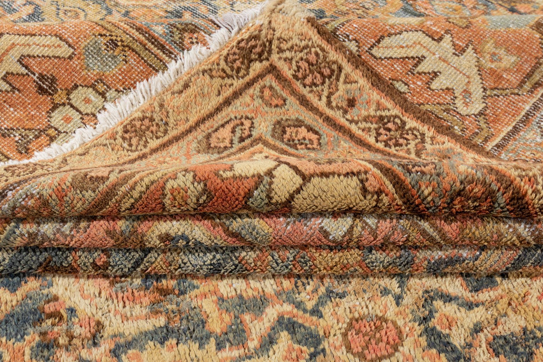 Beautiful hand-knotted antique Mahal wool rug with the blue field. This Persian rug has an orange-peach frame and beige and brown accents featuring an allover floral pattern design. 

 This rug measures: 12' 5