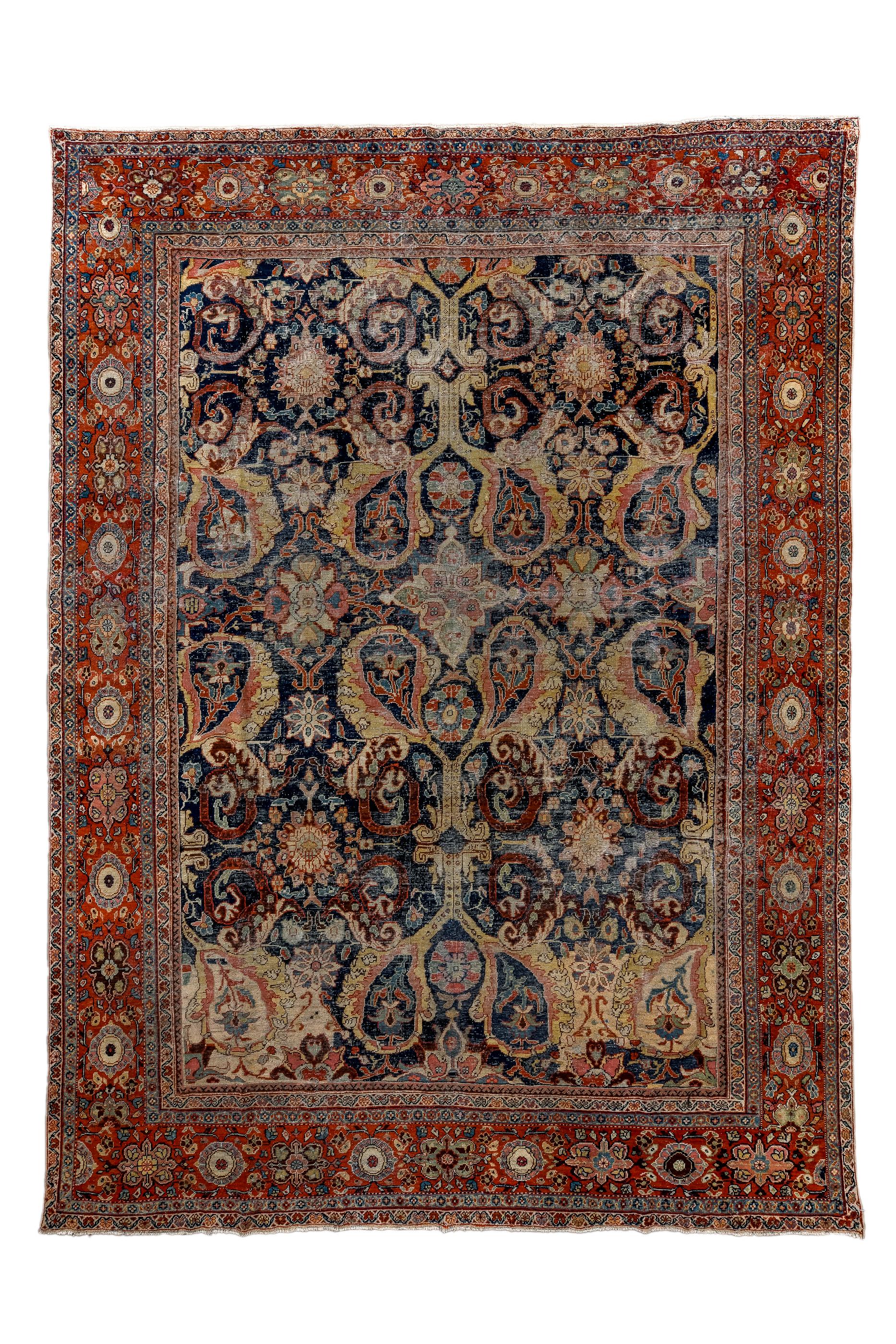 This very attractive and unusual village carpet shows giant botehs outlined with acanthus arabesques, on a dark indigo ground. Two botehs at the lower end have cream fields instead of the usual dark blue.  Red strip style border of octofoil