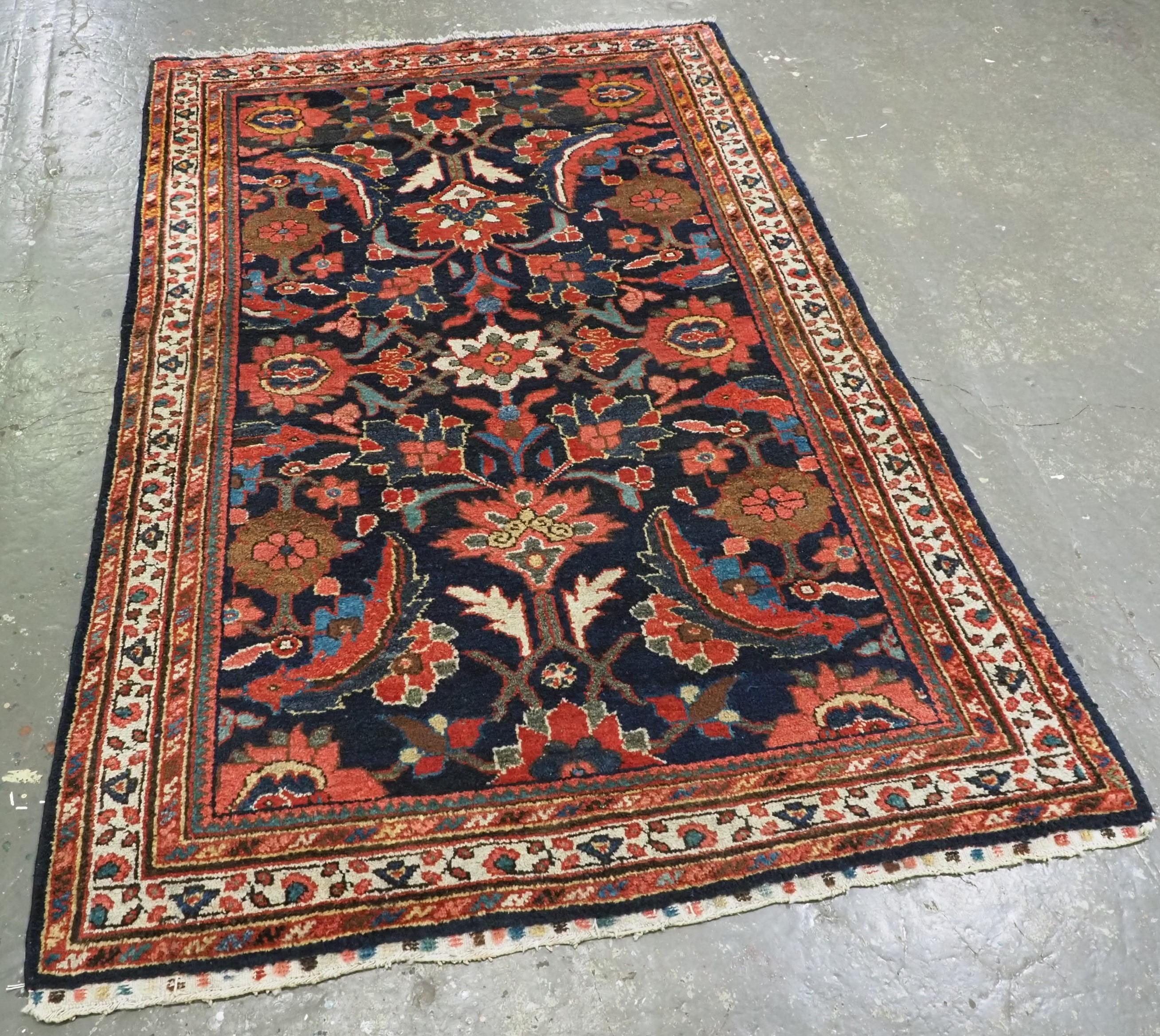 
Size: 6ft 7in x 4ft 1in (200 x 125cm).

Antique Mahal rug with large scale floral design.

Circa 1920.

The rug has an all over design of flowers and large serrated leaves on a dark indigo blue ground, the rug is framed by a fine ivory ground