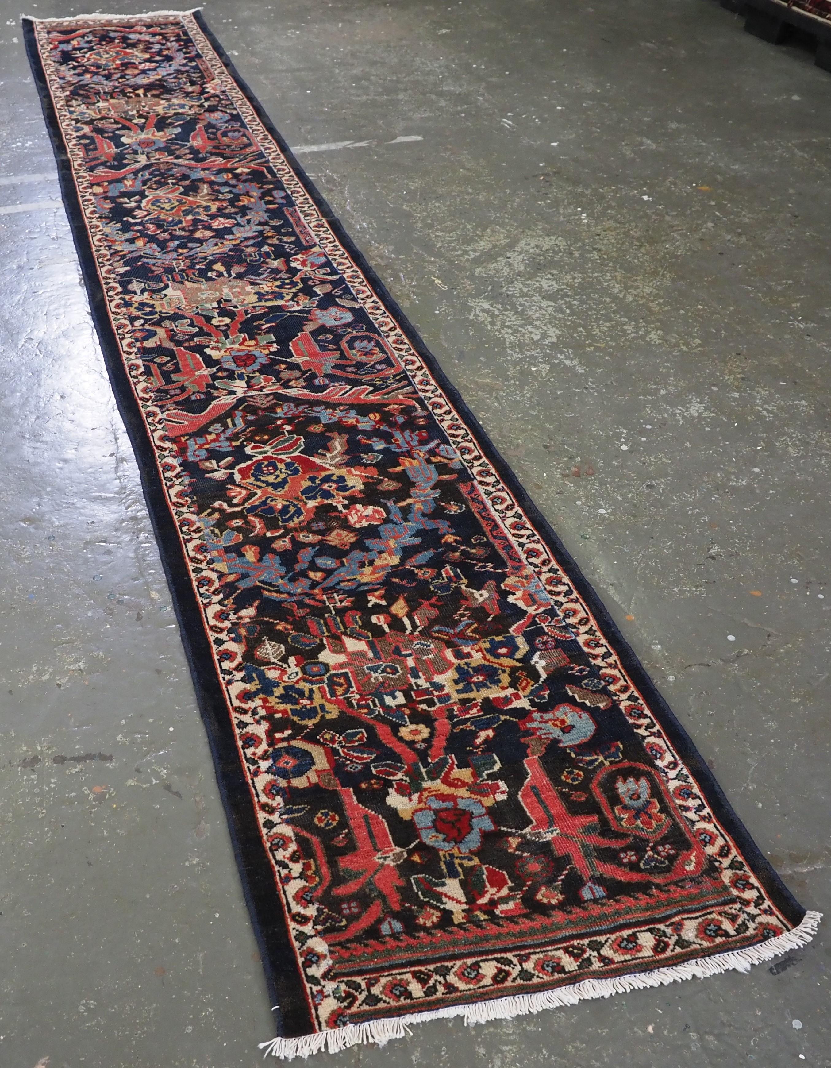 ize: 14ft 11in x 2ft 5in (455 x 73cm).

Antique Mahal runner of a very scarce narrow width.

Circa 1900.

The runner has a colourful feel with a classic large scale floral design on a dark indigo blue ground. The narrow ivory border frames the