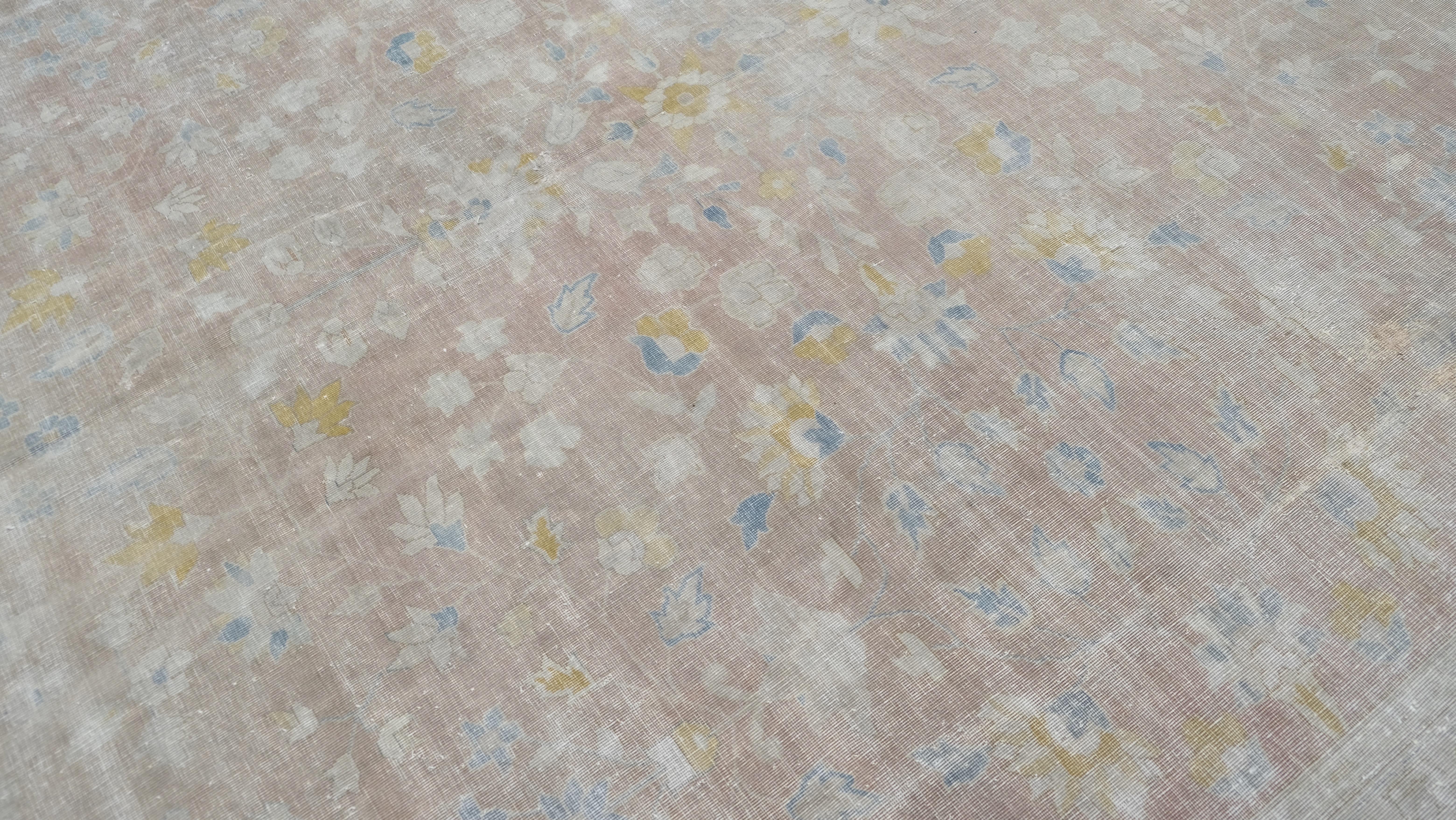 Dieser exquisite antike Mahal-Teppich aus handgeknüpfter Wolle zeigt ein zartes Arrangement floraler Motive, die in sanften Pastelltönen von Rosa, Blau, Creme und Hellgelb gehalten sind. Das verschlungene zentrale Feld wird durch eine puderblaue,
