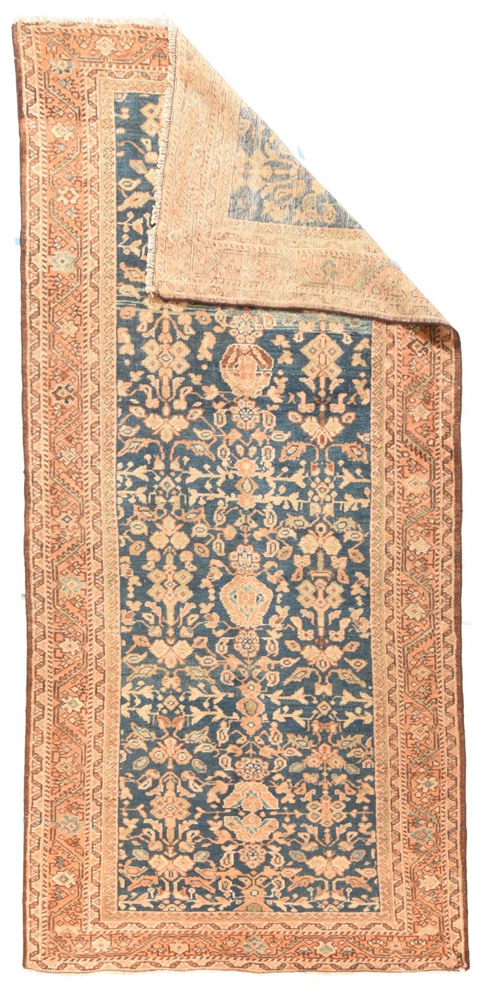 Antique Mahal Sultanabad rug measure 4'2'' x 9'4''. From Western Persia, this Kellegi (long rug) shows an abrashed sapphire ground with an essentially three column allover pattern of petal-winged palmettes, rosettes, horizontal short stems, and