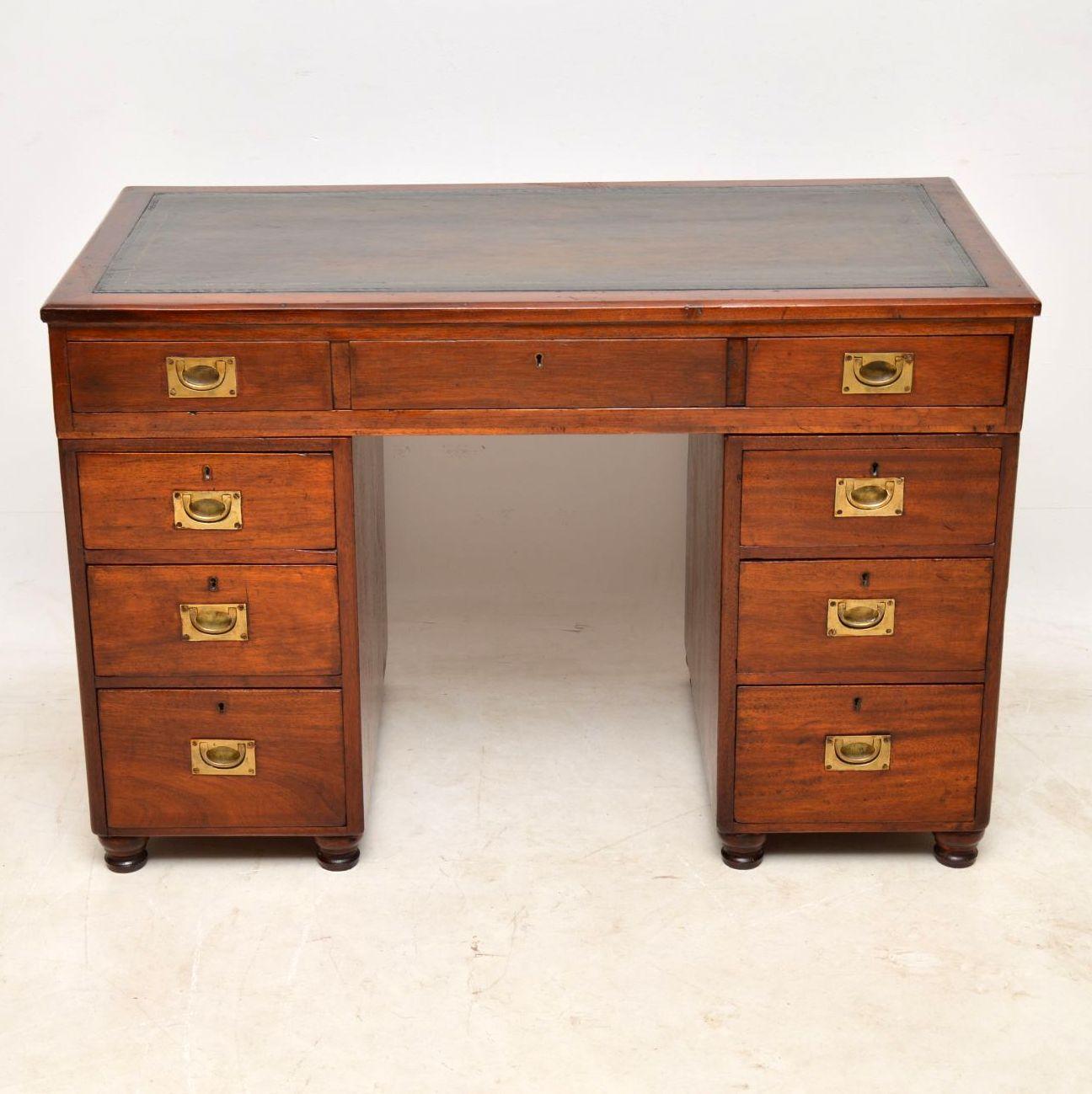 This antique Victorian mahogany desk is campaign style with the military inset brass handles. It's a small proportioned piece with a polished back and comes apart for easy transportation. The mahogany has a lovely rich patina and plenty of