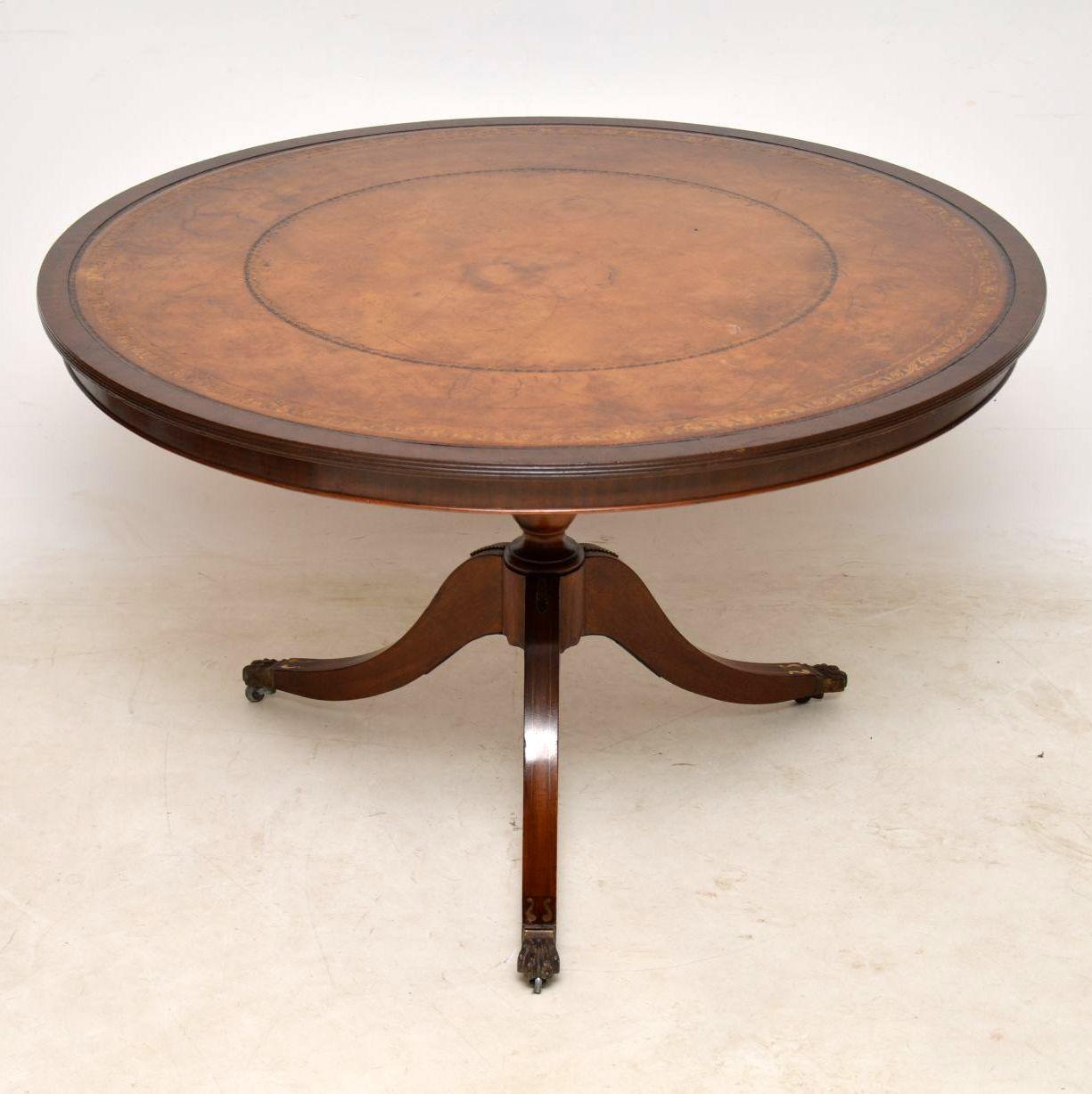 Antique Regency style mahogany leather top centre table in good condition and with a beautifully aged tooled leather top surface. The top edge is reeded and sits on tripod legs inlaid with brass, with brass claw feet and casters. I think the leather