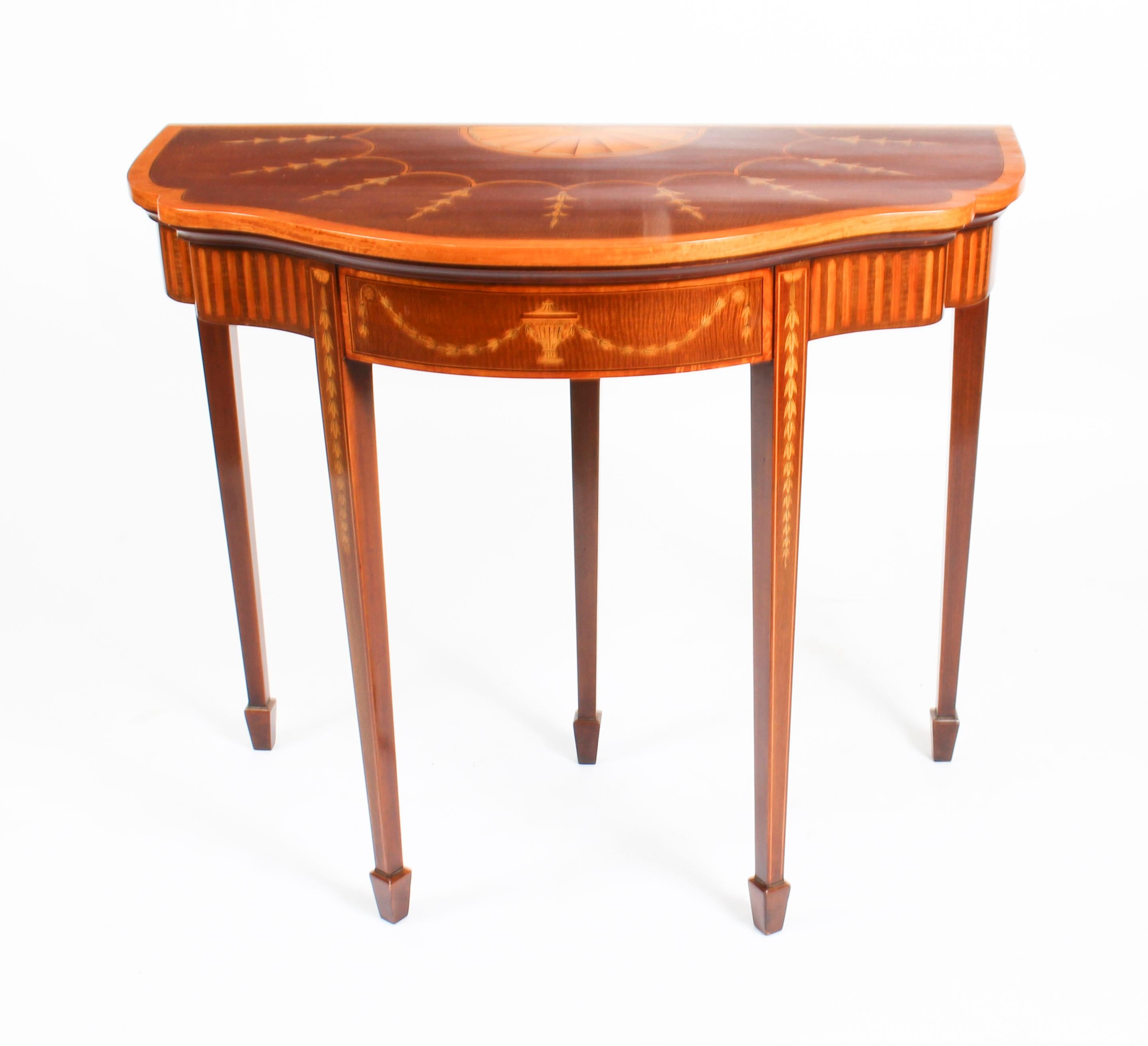 This is a beautiful antique serpentine card table, circa 1880 in date, and in superb George III style.

The card table is of mahogany with beautiful Neoclassical satinwood inlaid marquetry decoration of shells, garland and urns, the interior is