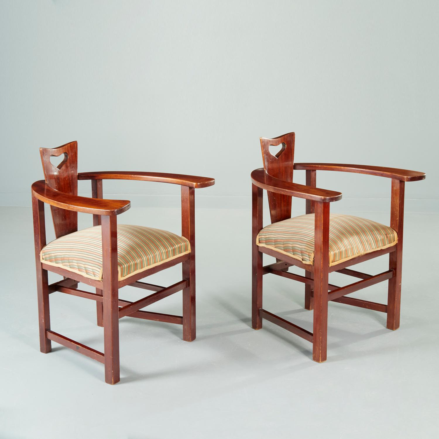C. 1896, Scotland, mahogany, the triangular back with heart-shaped cutout handle, the wide horseshoe armrests raised on four square legs joined by stretchers, padded striped sage and peach silk seat, unmarked. An iconic design from the Glasgow
