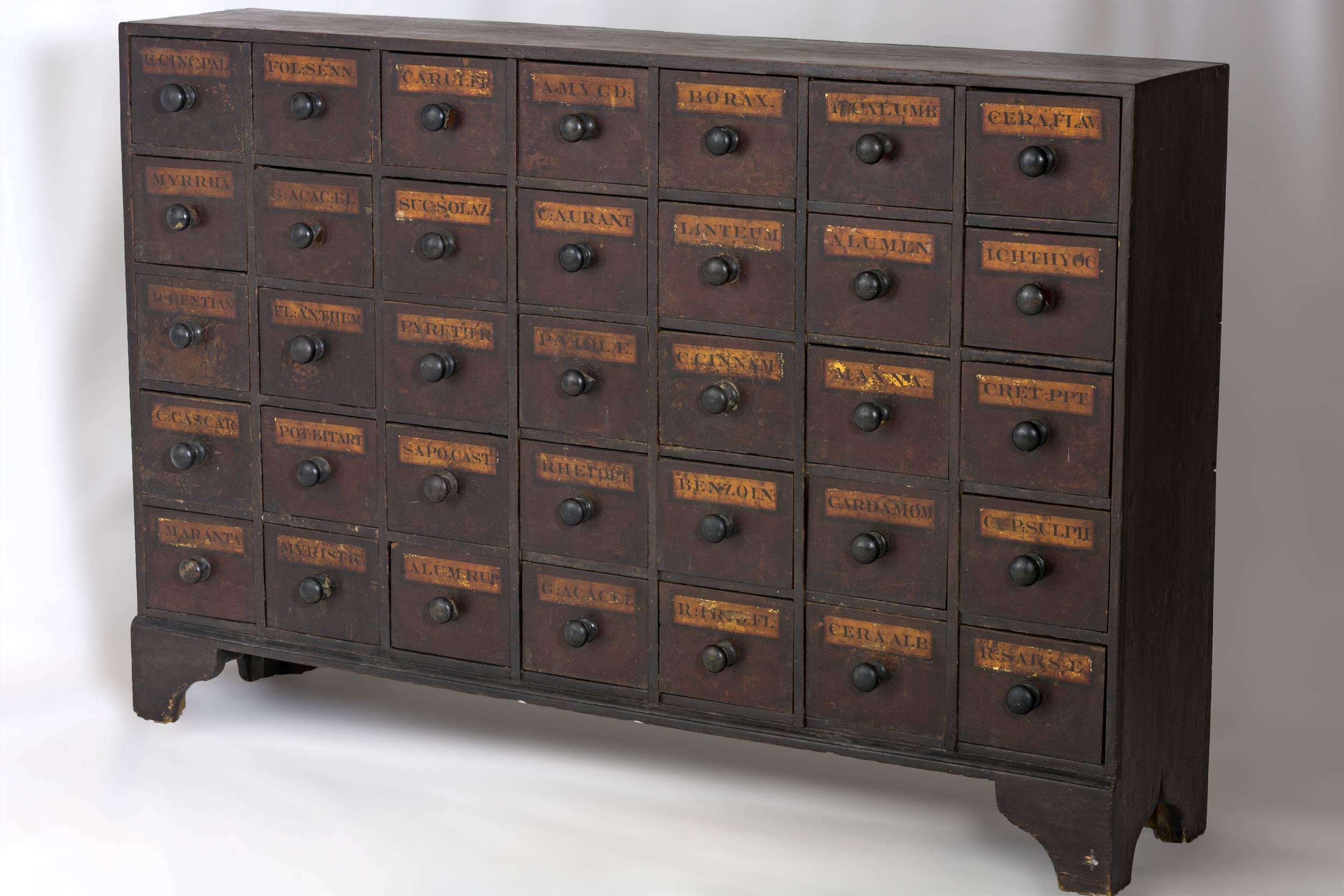 Mahogany apothecary chest with 35 drawers and 
painted labels on each drawer front indicating the 
contents. Turned wooden knobs with the case 
raised on bracket feet. Great original condition.
English, circa 1875. Measures: 32 ¼” x 50 ¾” x