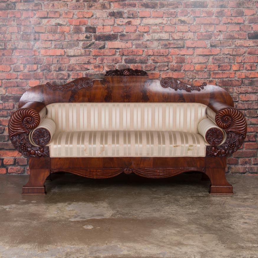 Drama and elegance combine in this stunning example of Swedish Biedermeier craftsmanship. This stunning antique sofa is made from polished flame mahogany with a deep, rich patina that seems to glow with life. Notice how the dramatic, large rolled