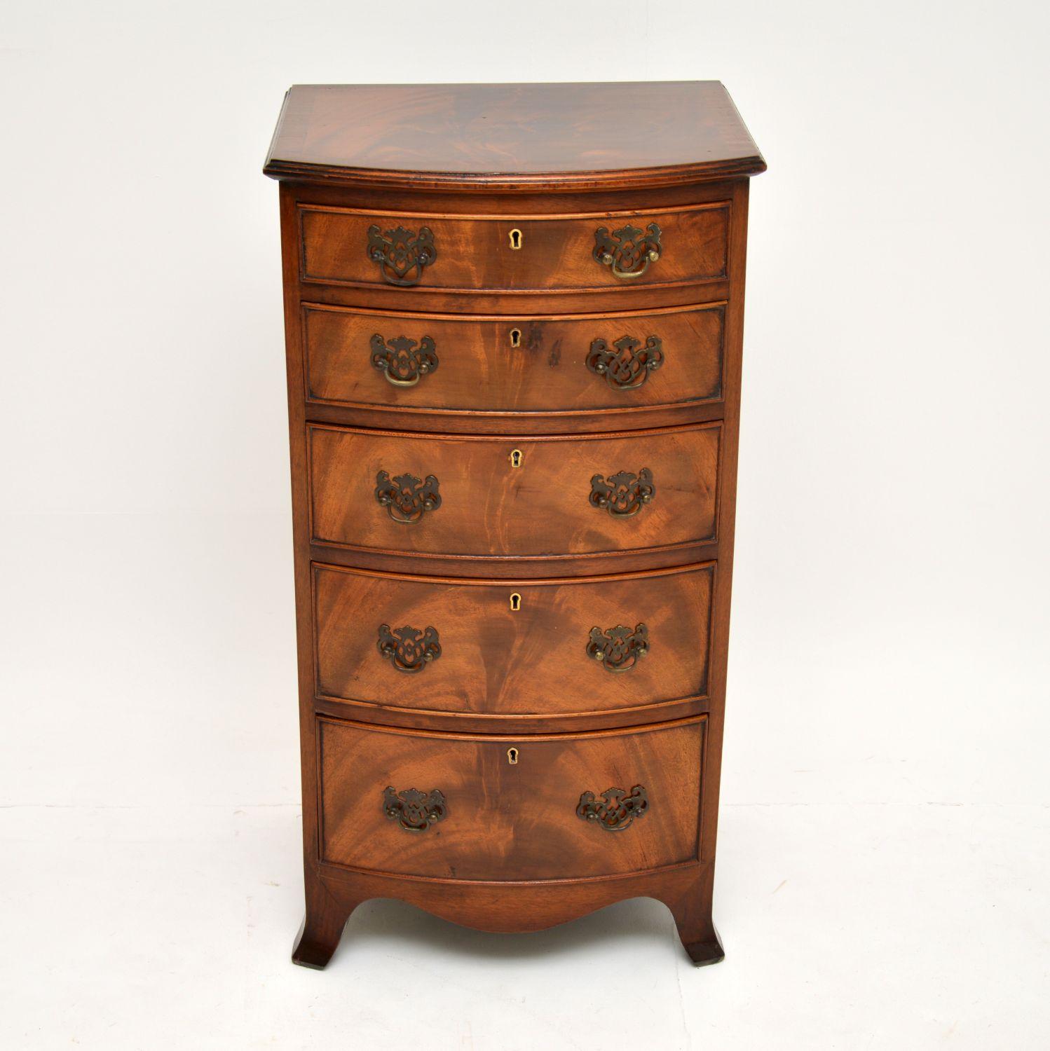 A beautiful slim antique bow front mahogany chest of drawers. This is in the Georgian style, it dates from around the 1900-1910 period.

It is of extremely high quality, with stunning flame mahogany veneers all on solid wood. There is a cross