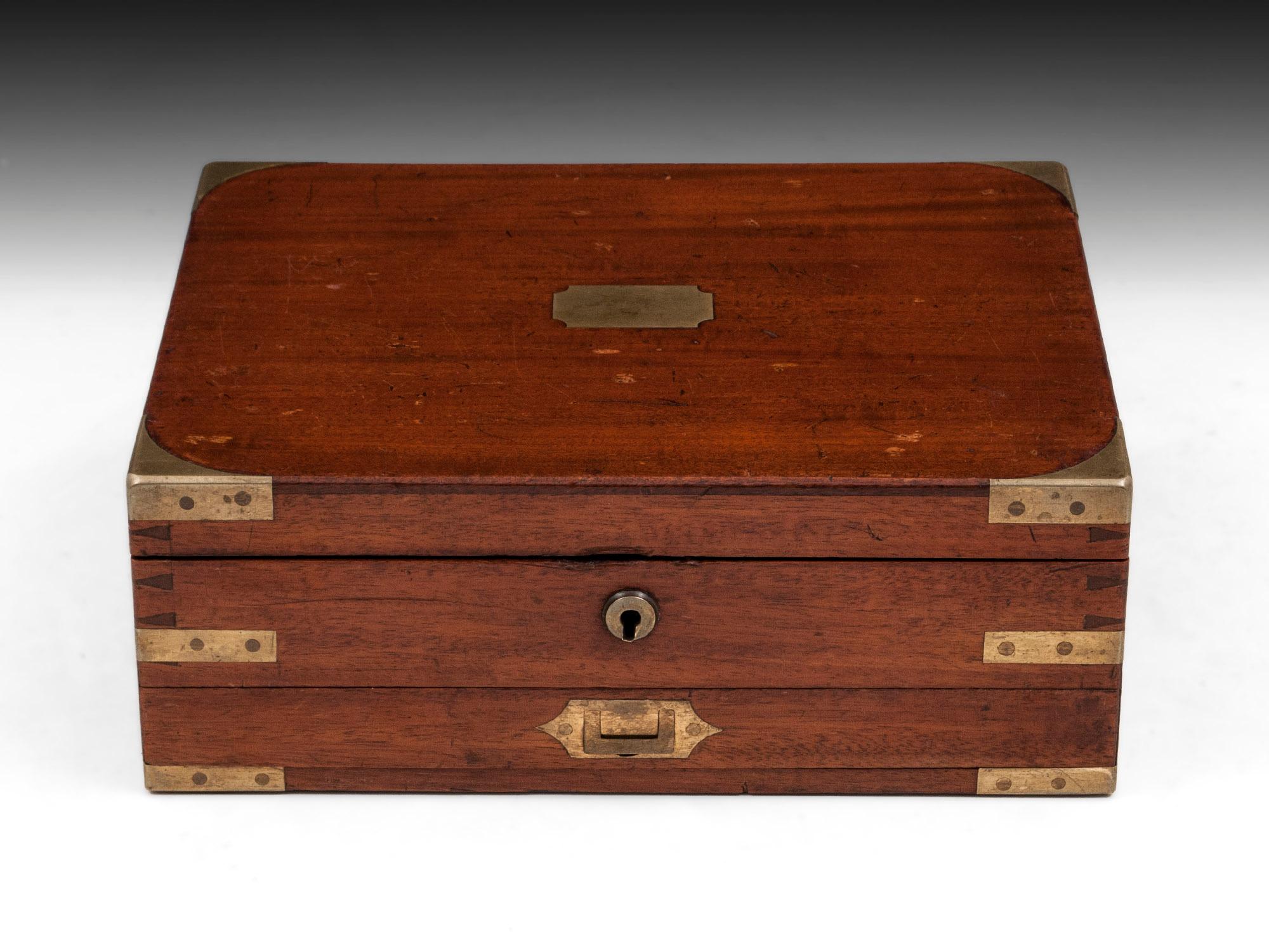 Mahogany brass-cornered dovetailed Artist's box with flush Campaign handle to the front drawer. The underside of the lid has an embossed burgundy leather insert to the interior of the lid, stamped “James Newman, 24 Soho Square, London”. Fitted tray
