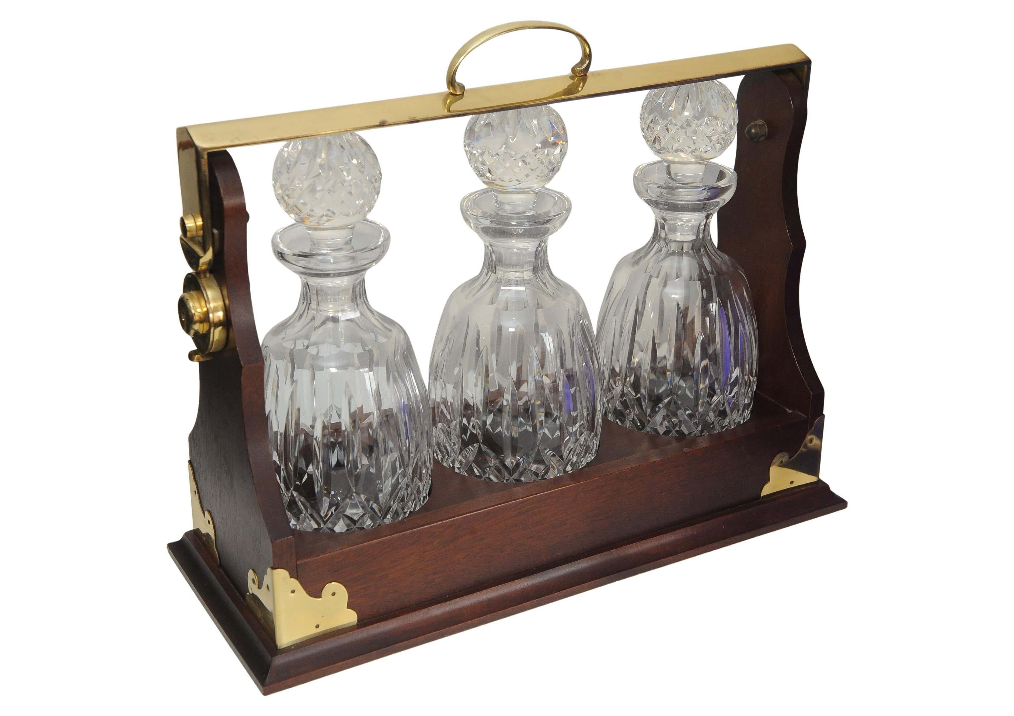 Englischer antiker edwardianischer Mahagoni & Messing Tantalus mit einem Satz von drei runden geschliffenen Glaskaraffen mit geschliffenen Glasstopfen mit dekorativen Elementen aus Messing   



