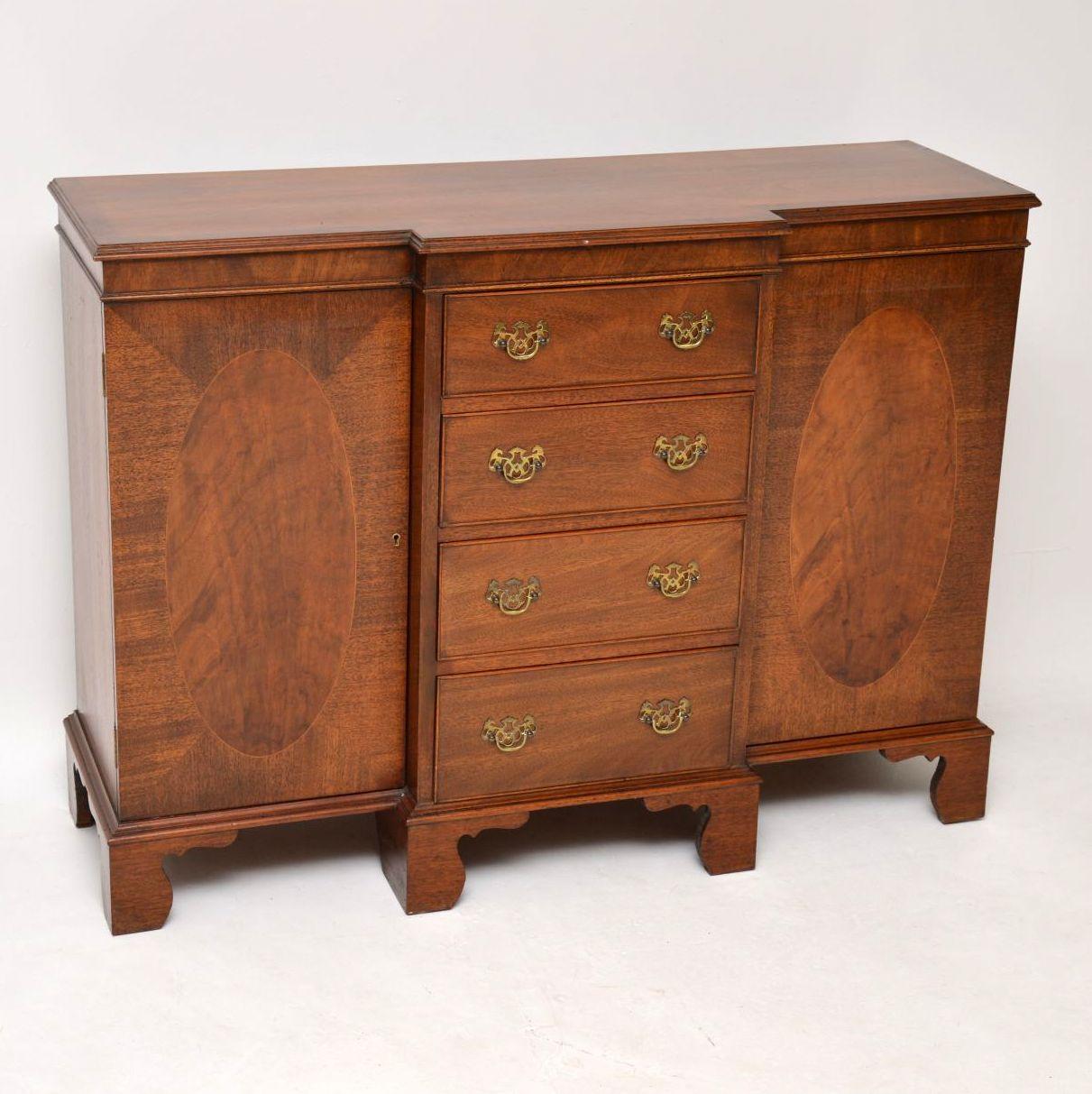 This small antique mahogany breakfront sideboard is of high quality and is a very solid piece of furniture. It dates from around the 1890-1910 period and is in good condition. The top has a strong cross banded edge. There are four graduated drawers