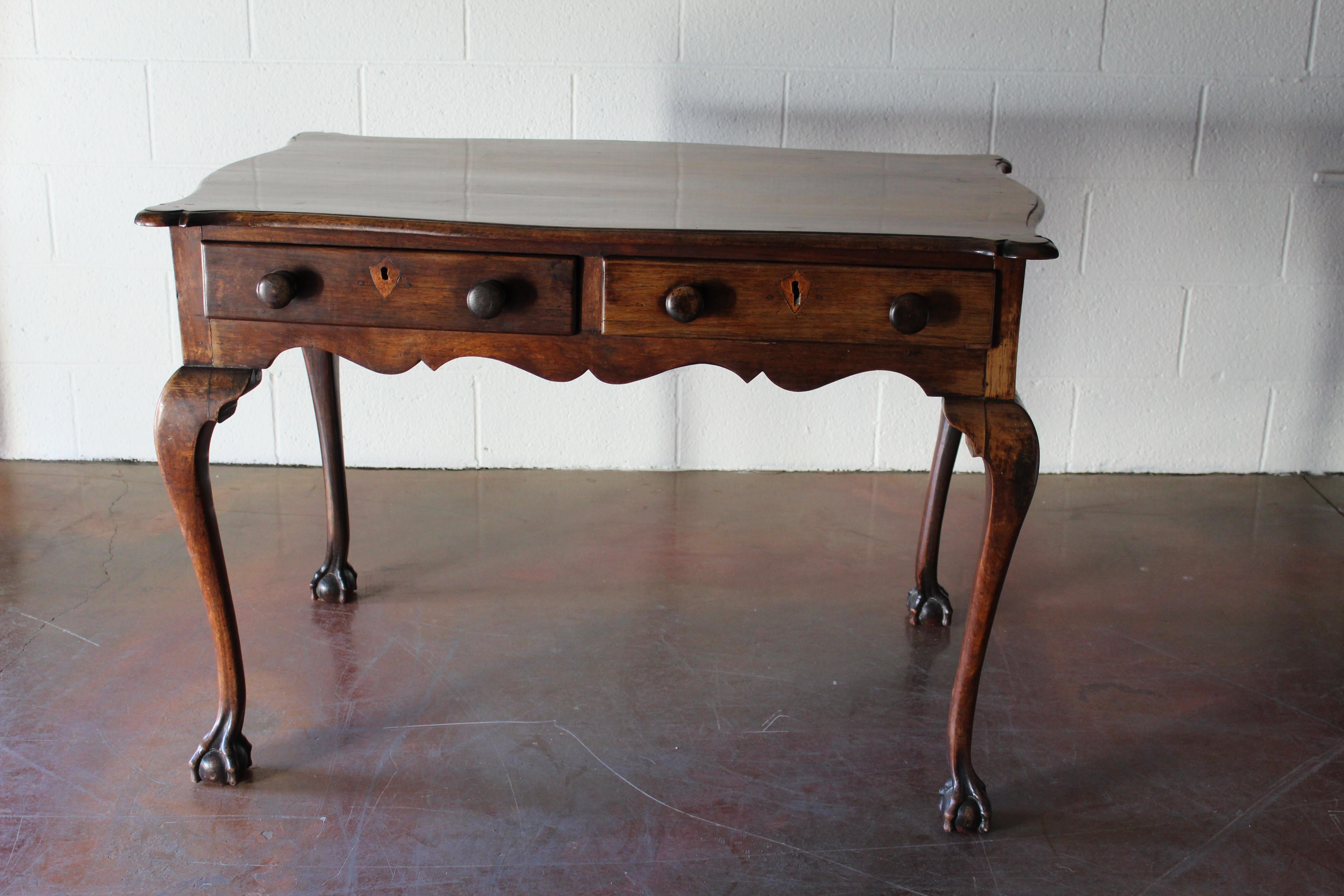 Beautifully proportioned cabriole leg 18th century English mahogany table with two drawers, two false drawers, and carved claw feet.