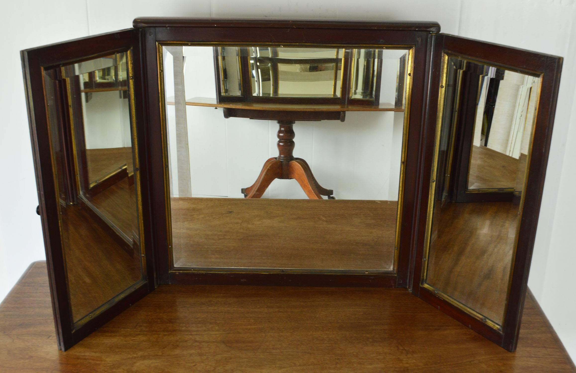 Very smart and superb quality campaign or folding gentleman's dressing table mirror.

The Honduras mahogany has a wonderful rich color. The brass trim is oil gilded and left in its original condition. (Not polished)

The bevelled mirrors are