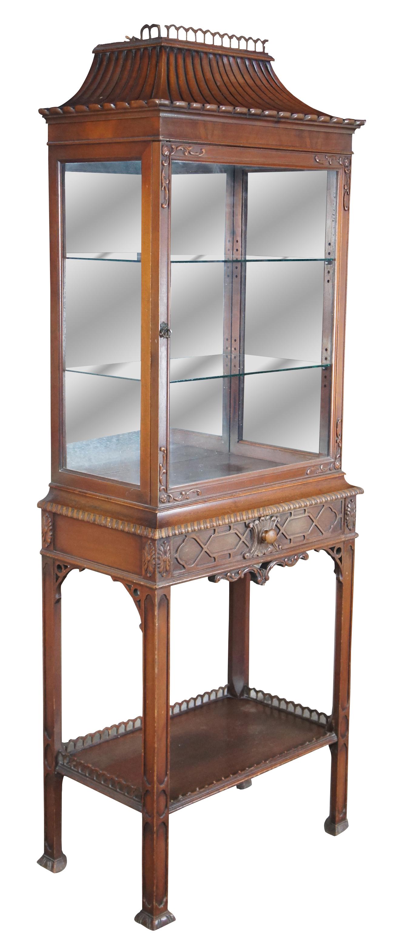 Antique Chinese chippendale display curio or vitrine cabinet, circa 1940s. Pagoda form top, carved door opening to interior with two adjustable height glass shelves, glass sides and a mirrored back. Single drawer below with blind fret front, shelf