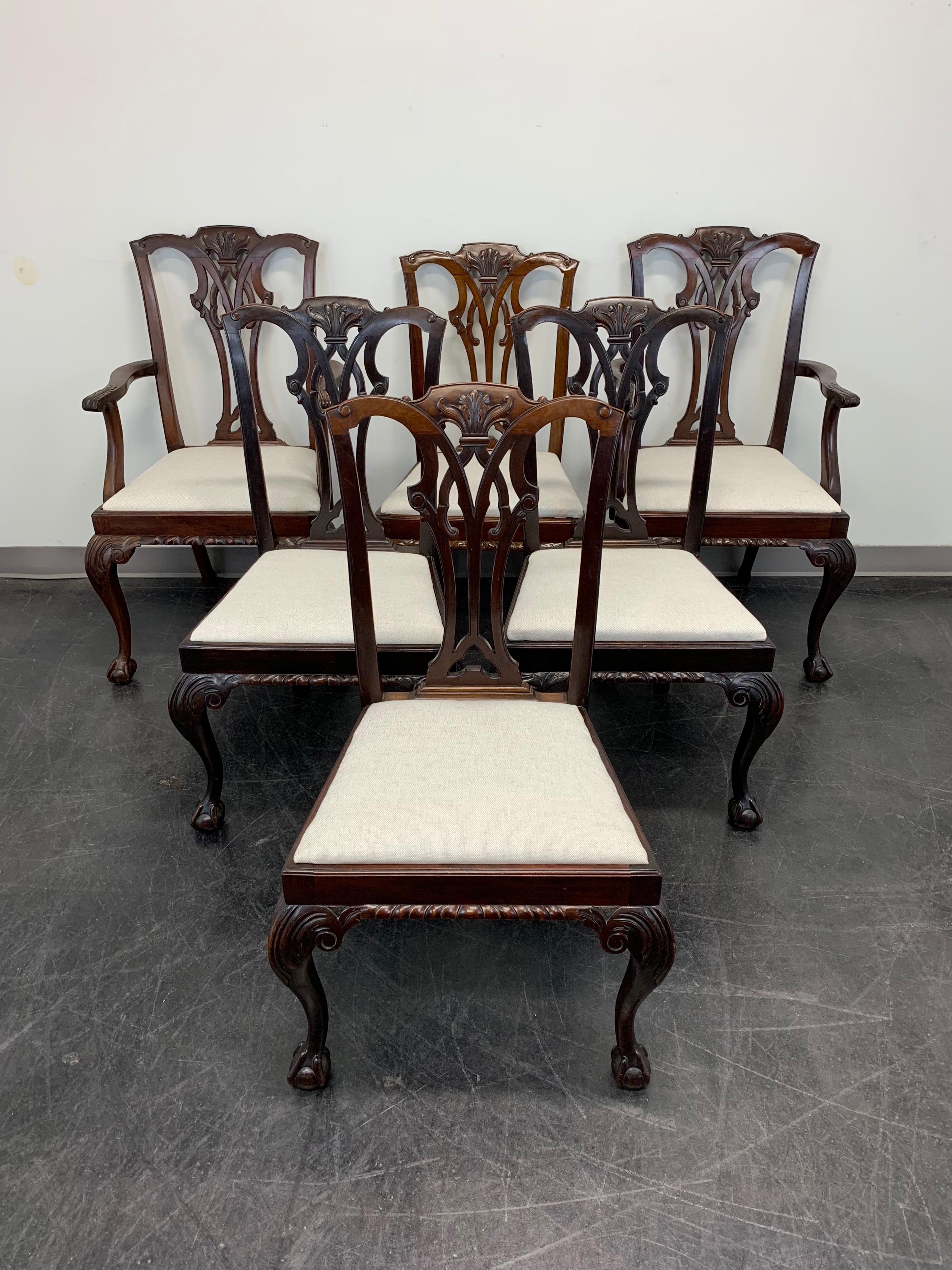 An antique set of six English Chippendale style dining chairs made for Pratt Brothers, of Streatham, London, United Kingdom. Solid mahogany, carved crestrail & backrest, curved arms with paw ends to armchair, carved apron, neutral cream color fabric