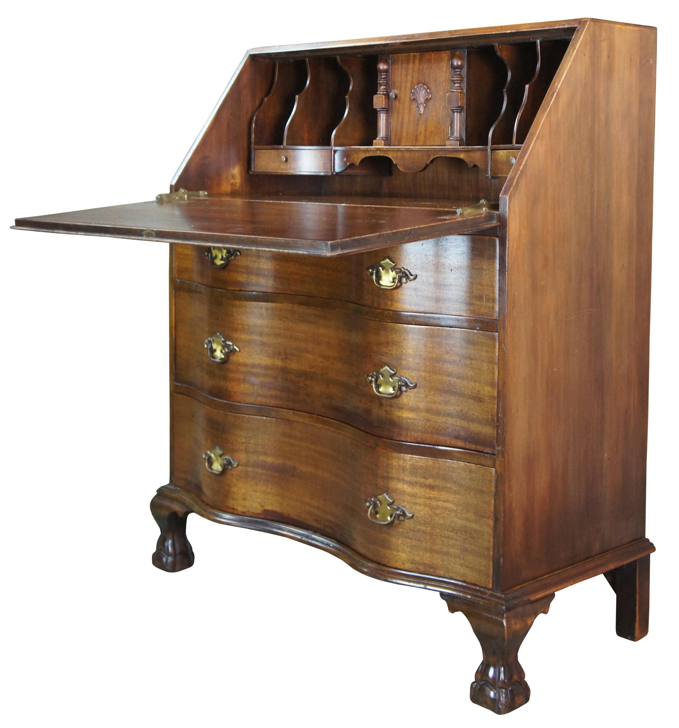 Antique Chippendale secretary, bureau or writing desk. Made from mahogany featuring a flip top that opens to multiple drawers and file storage. The dresser is constructed with an oxbow front with three drawers and federal style hardware over ball