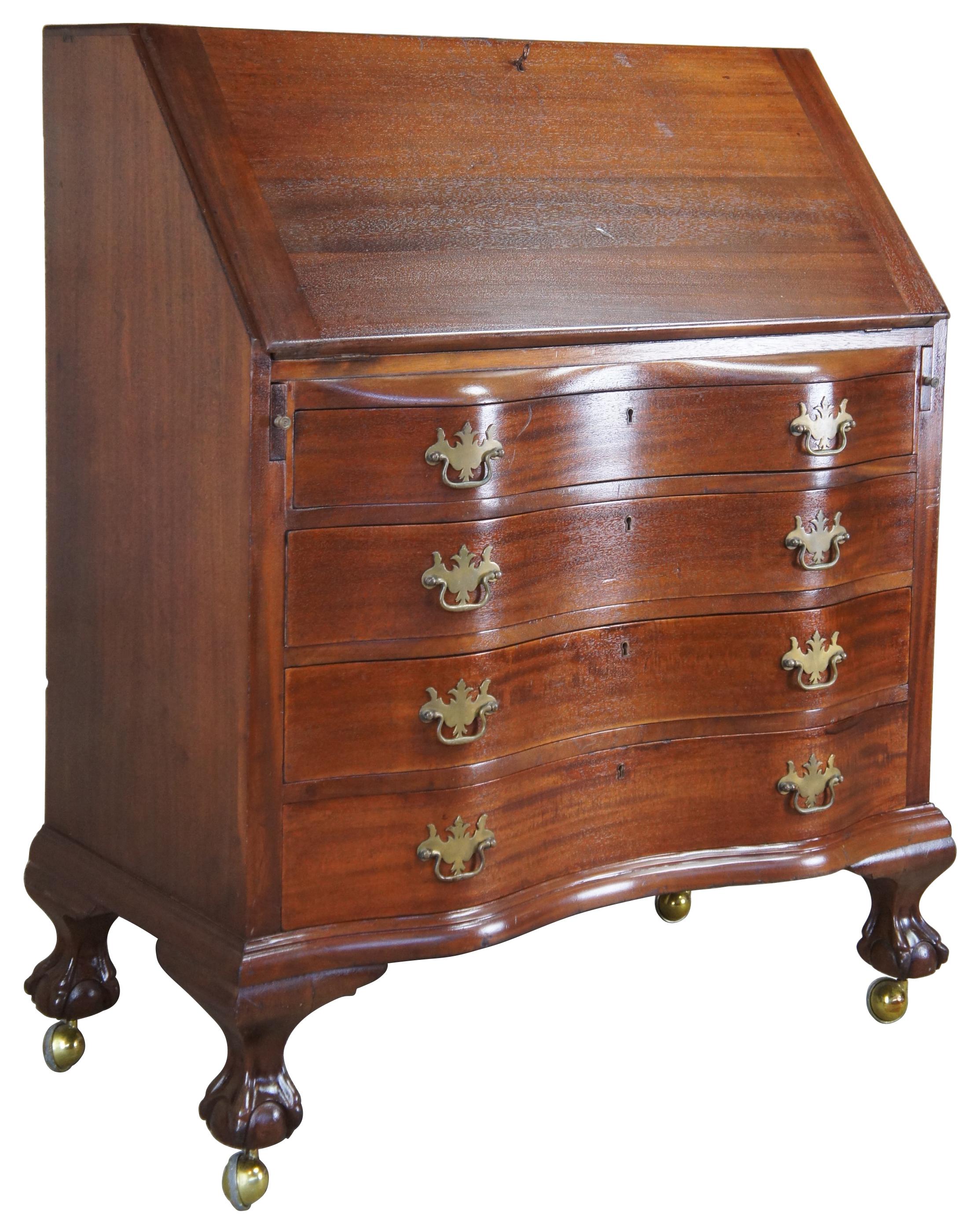 Antique mahogany secretary or writing desk, circa 1930s. Featuring a flip top that opens to multiple drawers, file storage and hidden compartments. The dresser or chest is constructed with an oxbow front with four drawers over ball and claw feet.
 