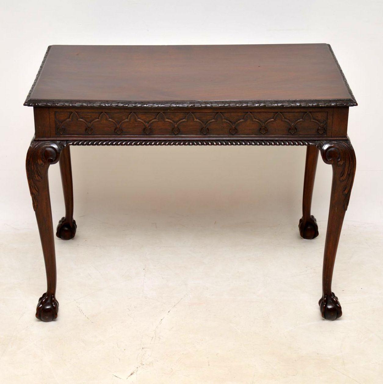This very impressive solid mahogany side table is antique Chippendale style & dates from around the 1890s period. It’s extremely fine quality and has some very intricate details. The top edge is finely carved with Gothic design mouldings below.