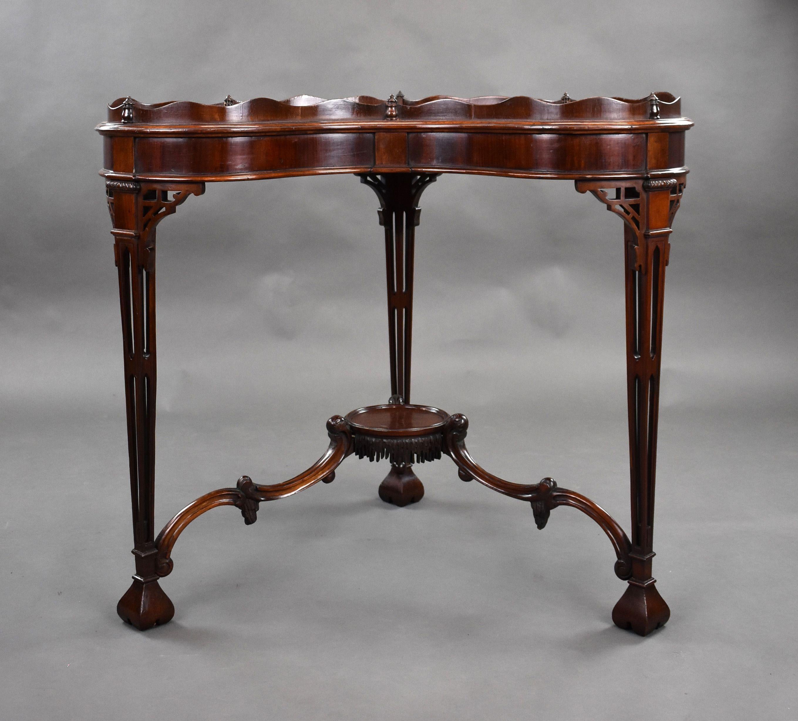 For sale is a good quality, unusual, antique mahogany Chippendale style silver table. Having a shaped galleried top, above three ornate legs with a central under tier, united by an elegant stretcher, this unusual table remains in very good condition