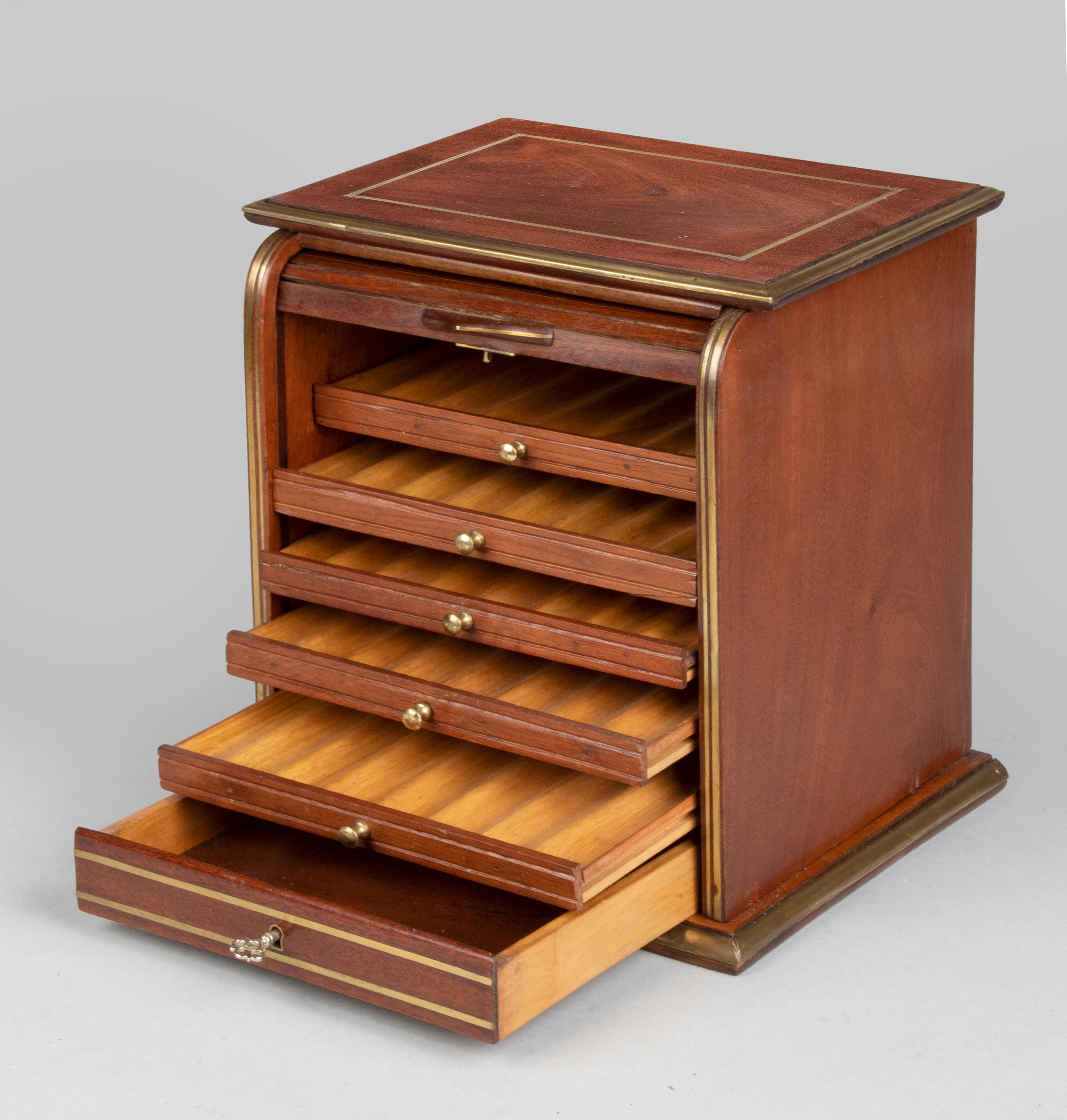 Beautiful antique cigar box from the early twentieth century. The interior is furnished with five drawers for cigars and an open drawer at the bottom. The box opens and closes with a shutter. The exterior has a fairly simple design, which shows off