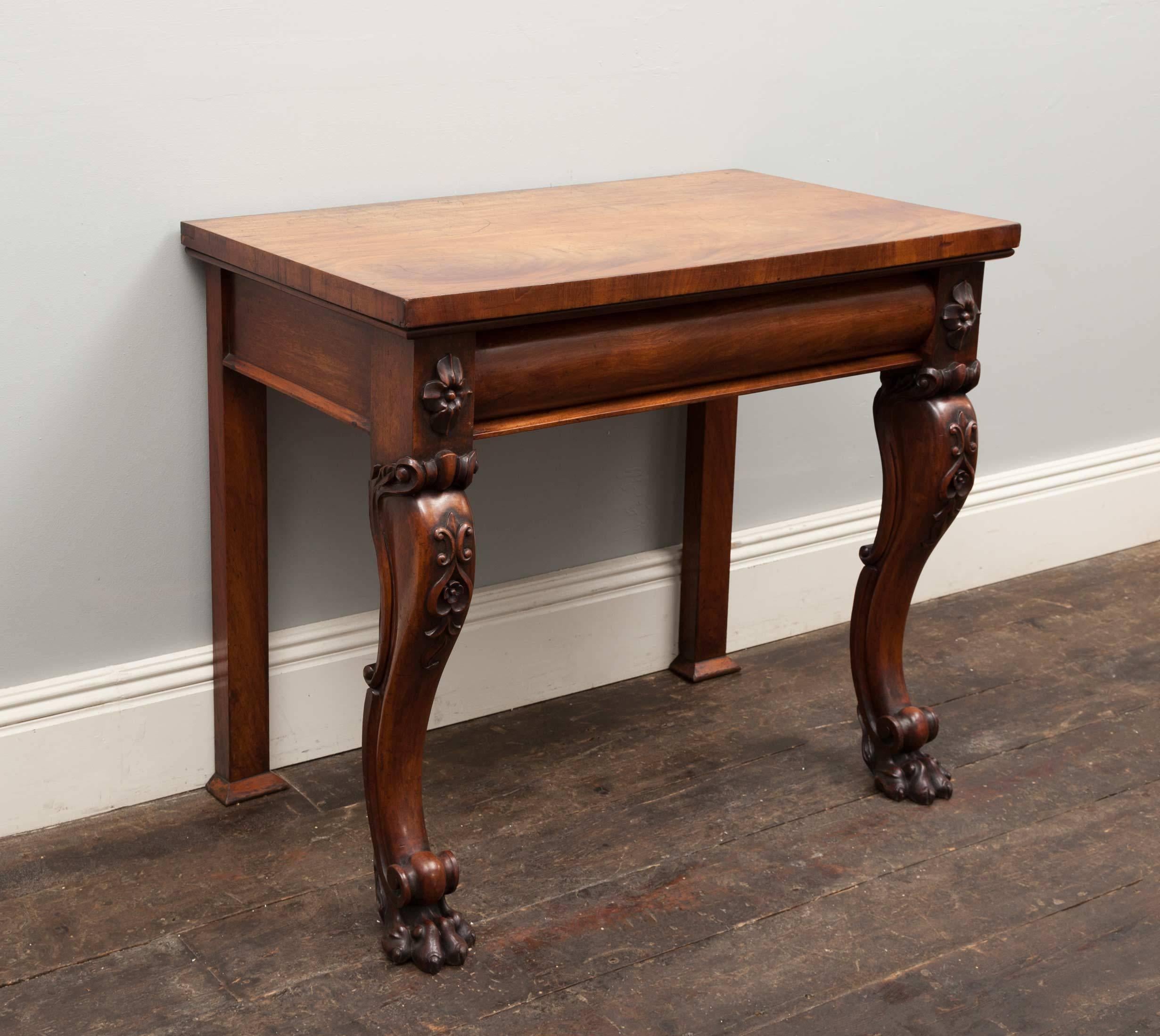 An antique mahogany console table of fine quality and proportions. The two front scrolled legs with carved knees terminate with paw feet. The pull-out drawer with a barrel shaped front is flanked by carved floral end-blocks.

This table is in