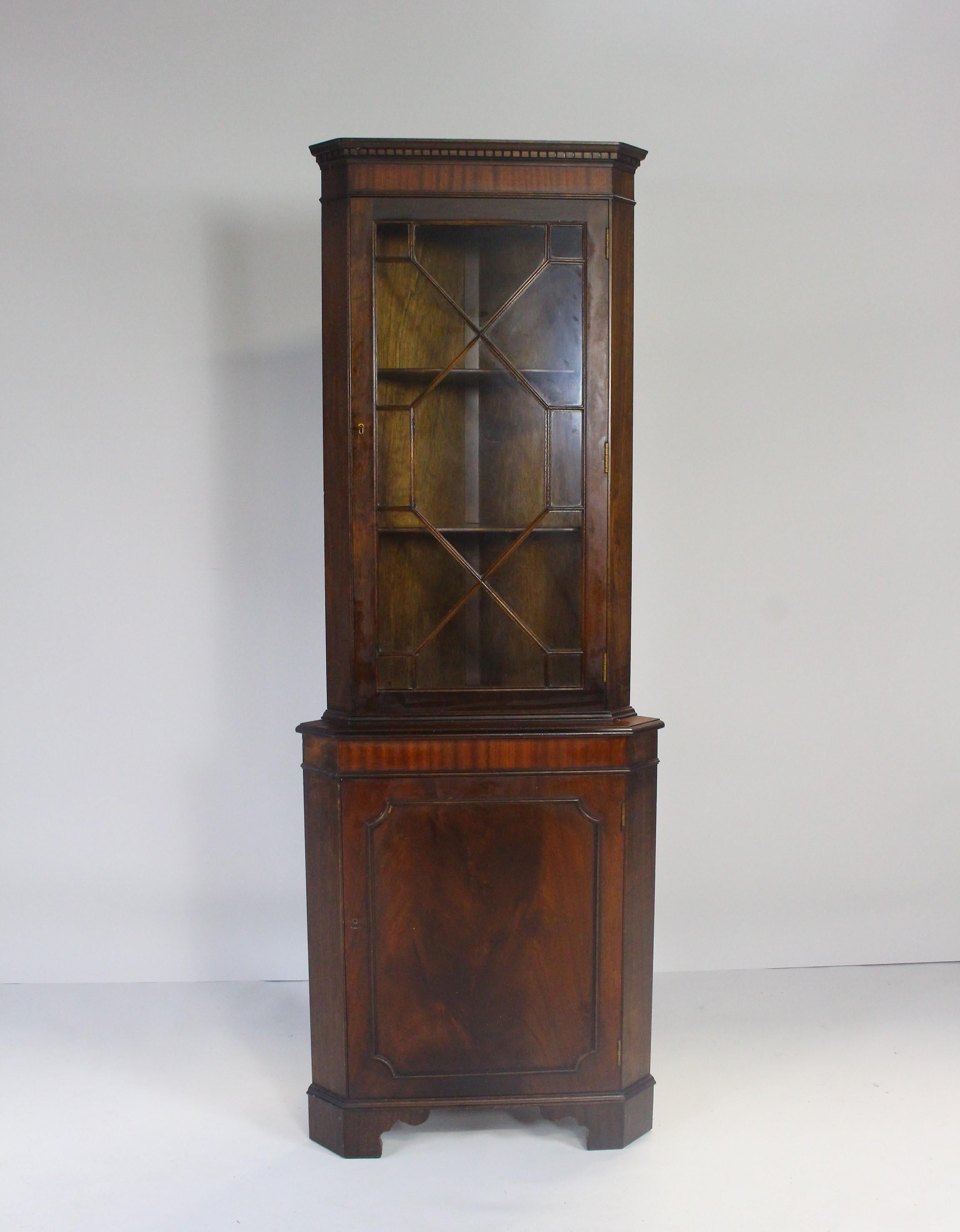 Antique mahogany corner cabinet with glazed display above a cupboard.
A beautiful, functional piece of furniture with nice wood grain on the front of the door.
Slight scratches.