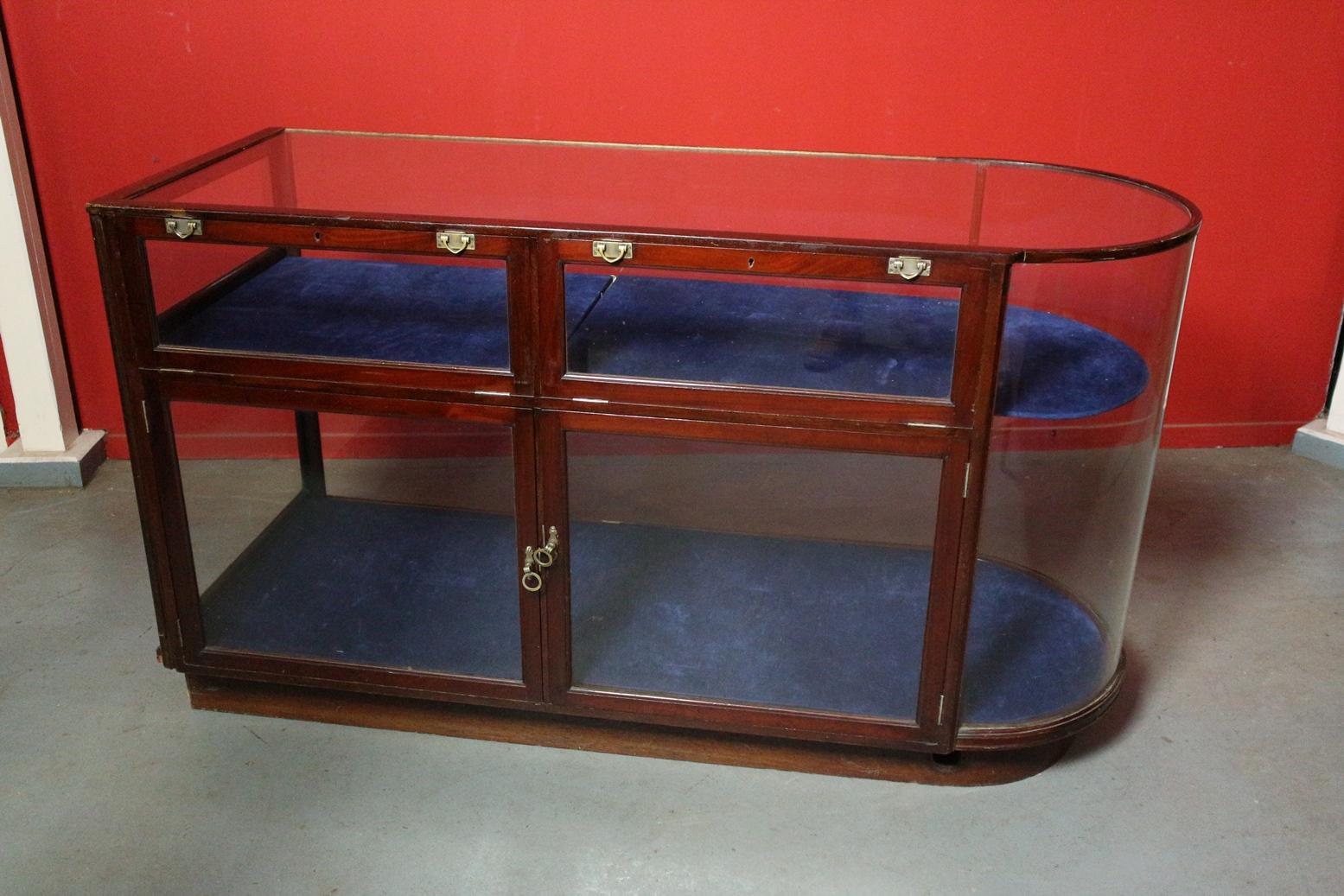 Beautiful antique mahogany counter / display case with curved glass. Equipped with adjustable shelf and 4 doors. Entirely in good and completely original condition.

Origin: England
Period: Approx. 1900
Size 157cm x 60cm x h.90cm.