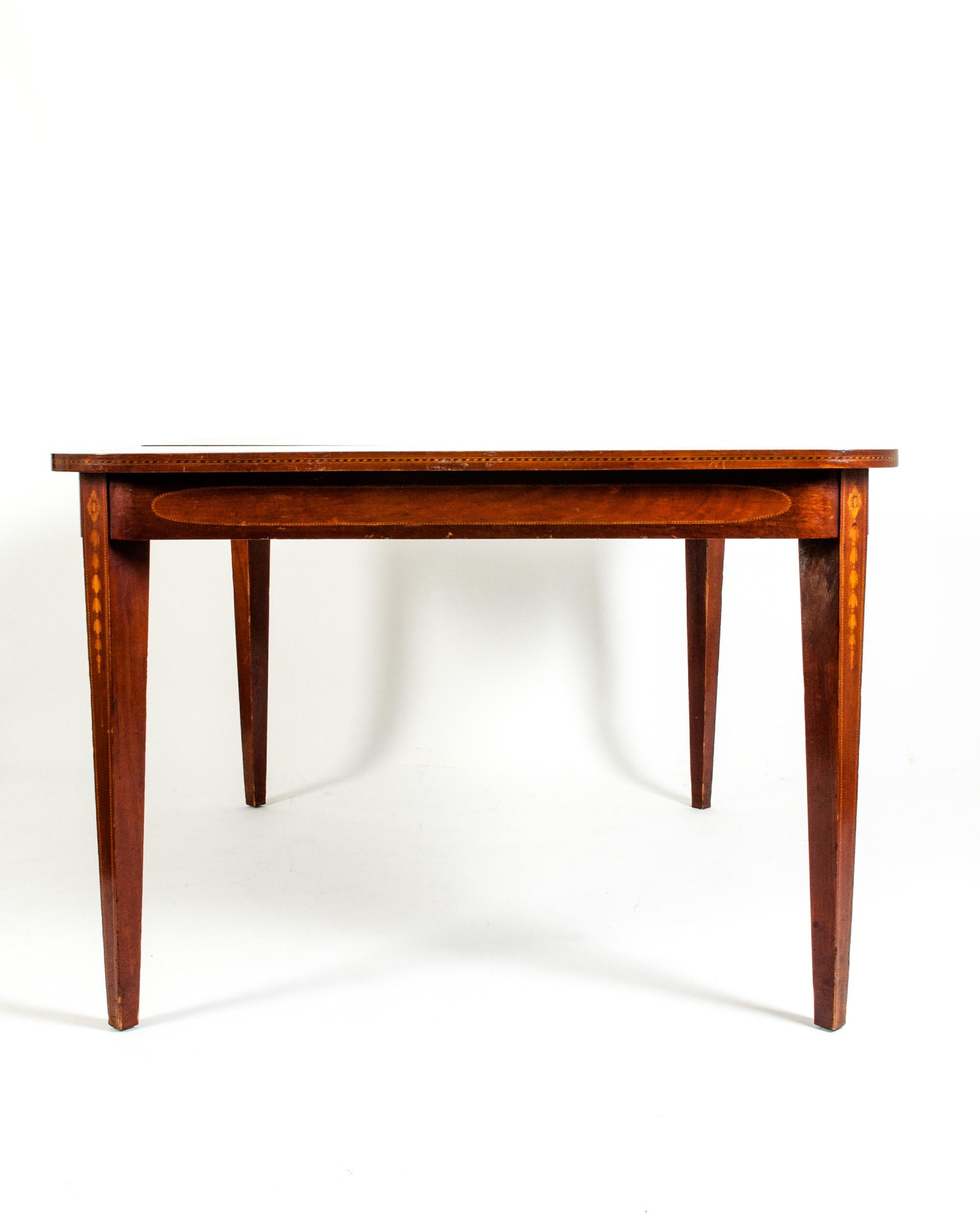 Antique English mahogany dining table with inlaid design details. The table is in excellent antique condition. Minor wear consistent with use / age. The table measure about 58 inches L x 44 inches W x 30 inches H. The table includes two interior