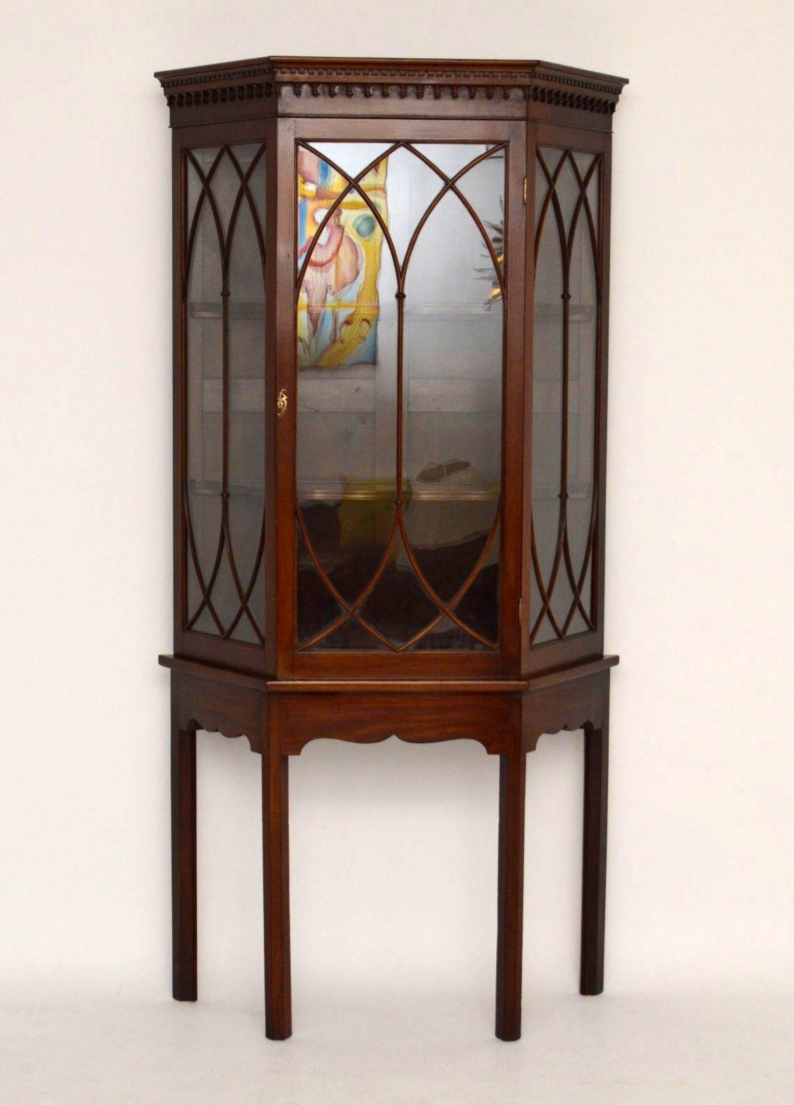 Impressive antique mahogany display cabinet in good original condition, with original color and patina. The top cornice has a dental frieze with tear drop mouldings below. The astral glazing is of Gothic design and the shelves inside the cabinet are