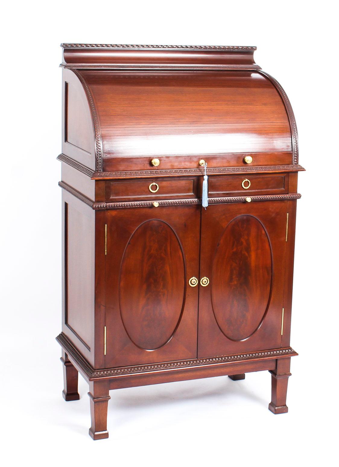 A superb flame mahogany drinks cabinet, by the renowned retailer Finnigans, Circa 1880 in date.

The upper section is fitted with a tambour slide opening to an onyx lined bar with bevelled mirror back, brass fittings, cut glass decanters and