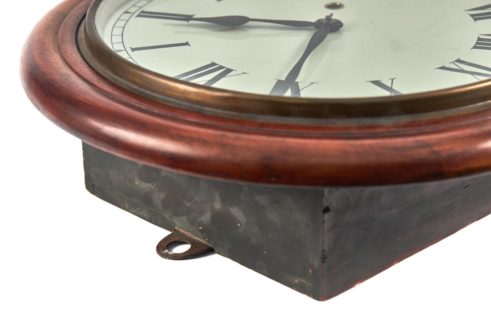 Antique Mahogany Drop Dial Wall Clock, having a quality mahogany circular glazed door opening to reveal a painted dial with original hands and an 8 day movement above a drop case with a glass window flanked by carved mahogany scroll supports with