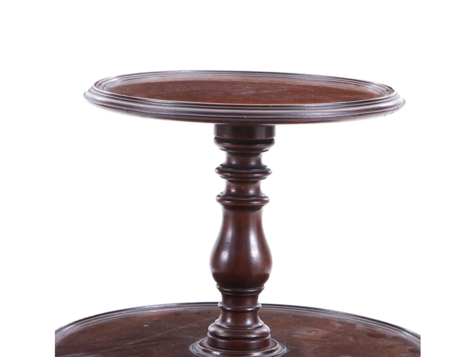 A lovely mahogany 19th century dessert serving table-known as a dumbwaiter. 
Features 3 circular serving table tops of varying heights and sizes. A beautiful Turned Center Column with a Carved 3 leg Base with Splayed legs, recessed casters, and a