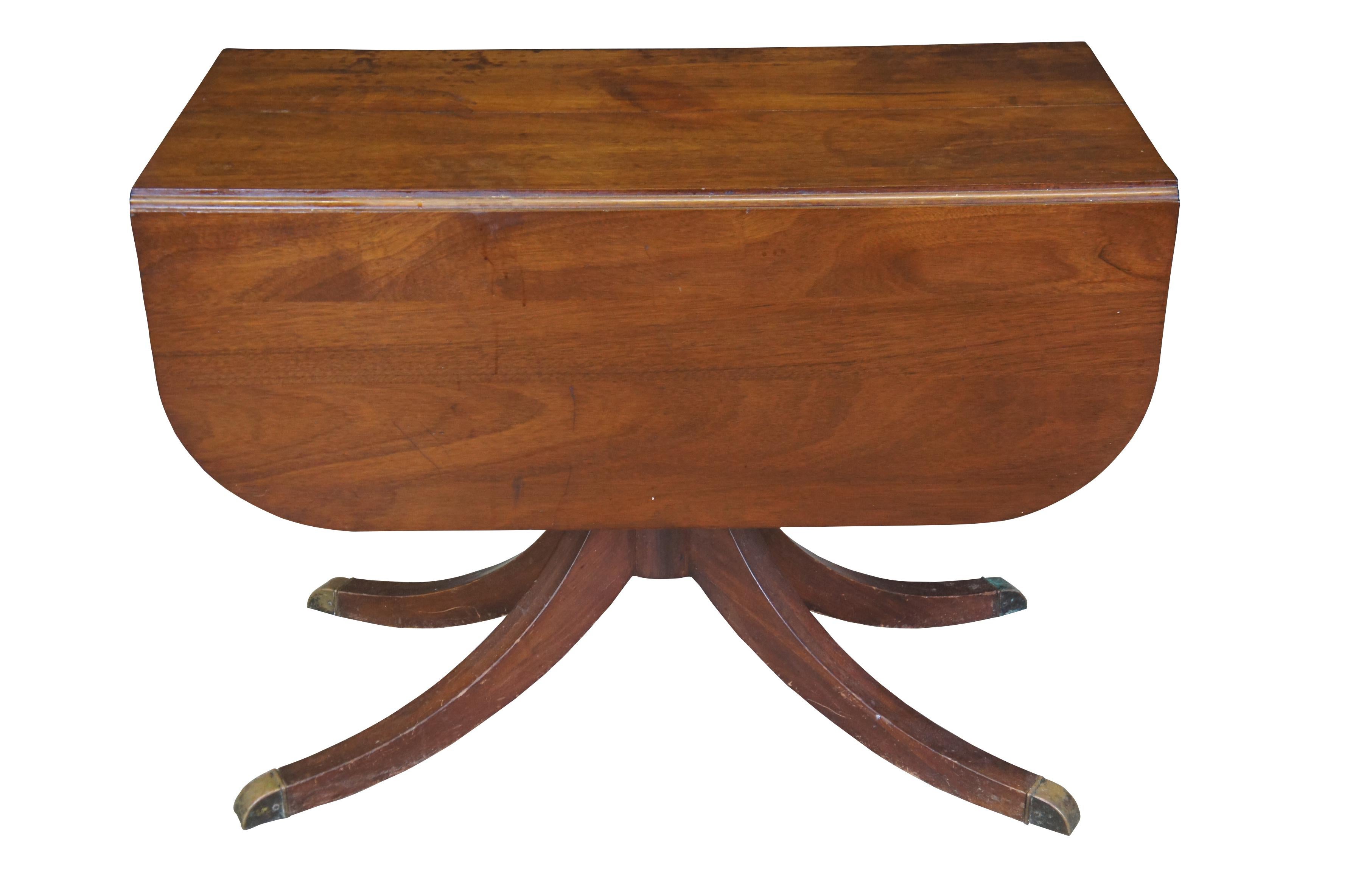 Antique drop leaf game or dining table.  Made of mahogany featuring Duncan Phyfe styling with brass capped feet and extendable top.

Dimensions:
21