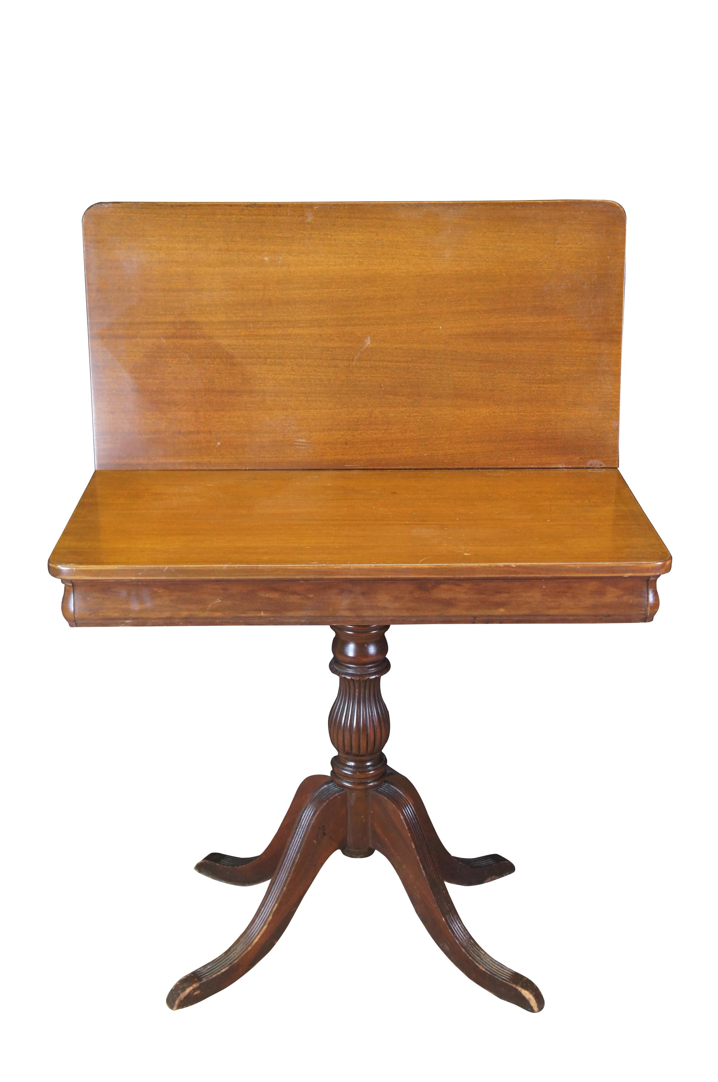 Antique flip top game table.  Made of mahogany featuring Duncan Phyfe styling with fluted legs and post that support the top, which opens to reveal a storage compartment.

Dimensions:
17