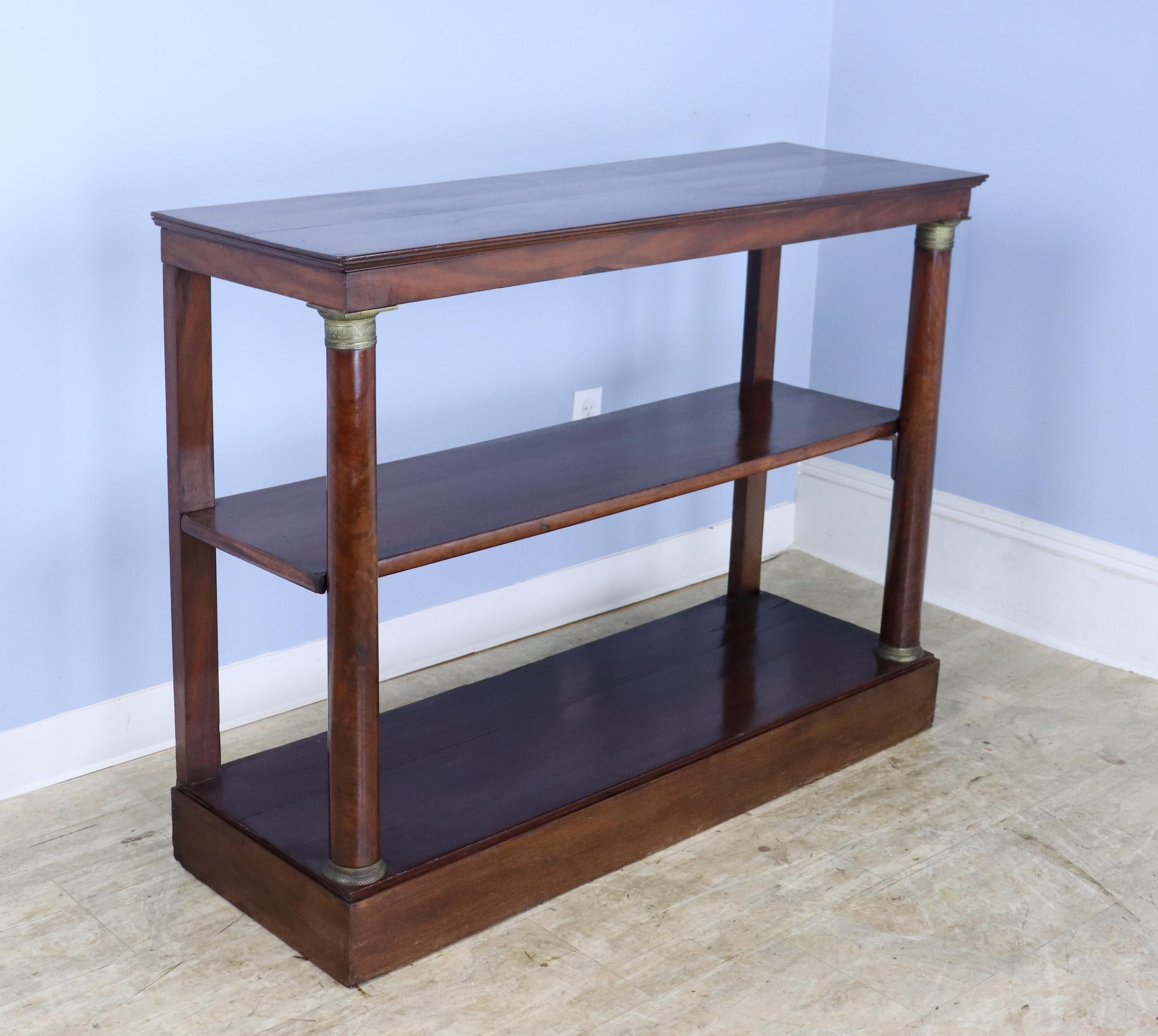 An elegant Empire style mahogany console with brass accents. The color and patina on the wood are very good. There are some areas of wear, highlighted in the thumbnail photographs.