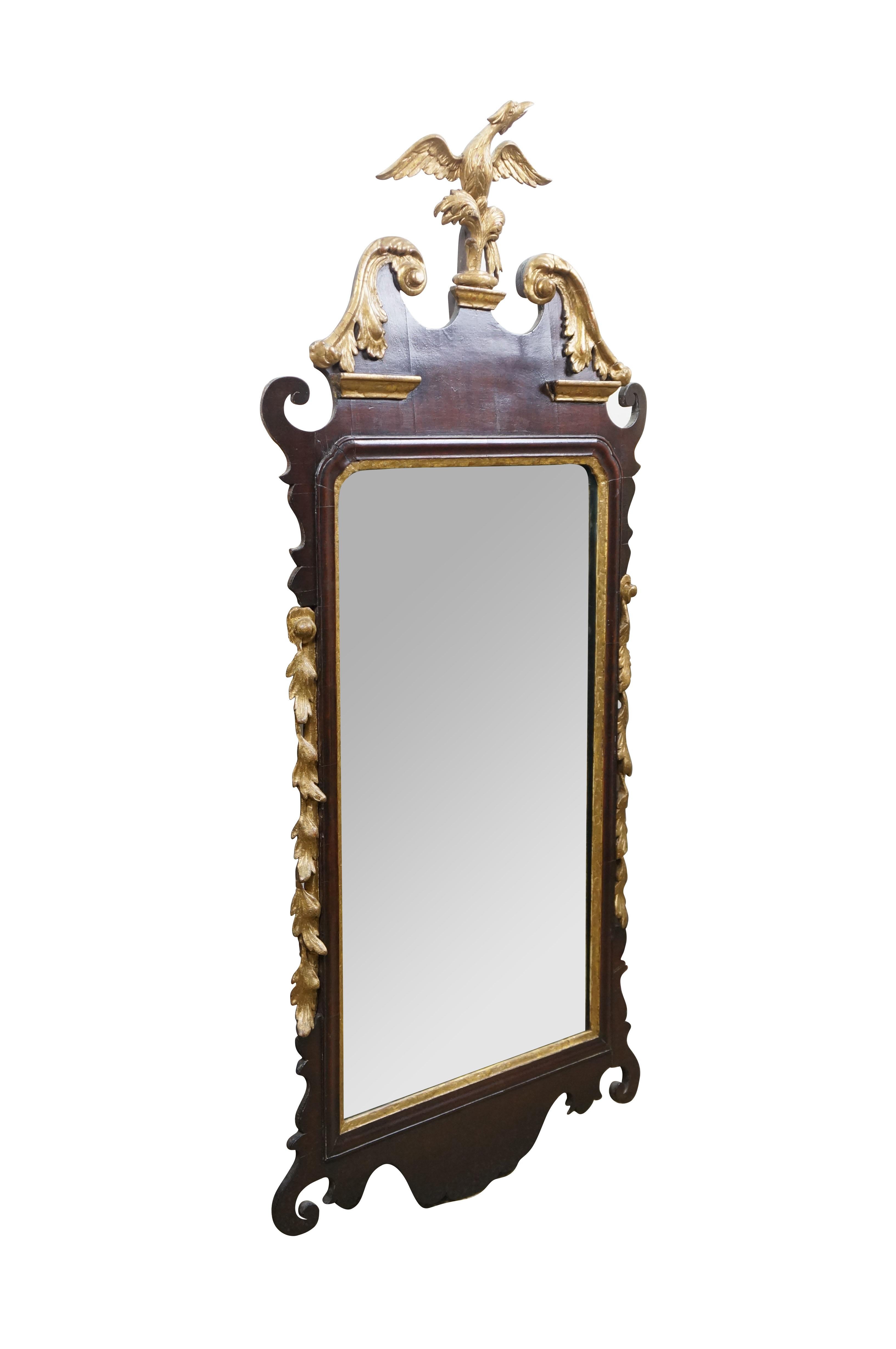 Antique Federal / Chippendale style wall / mantel / vanity / mirror. Rectangular form, framed in mahogany with scrolling fretwork at the top and bottom, gold gilt border around the mirror glass, lines of gilt leaves on each side edge, and topped