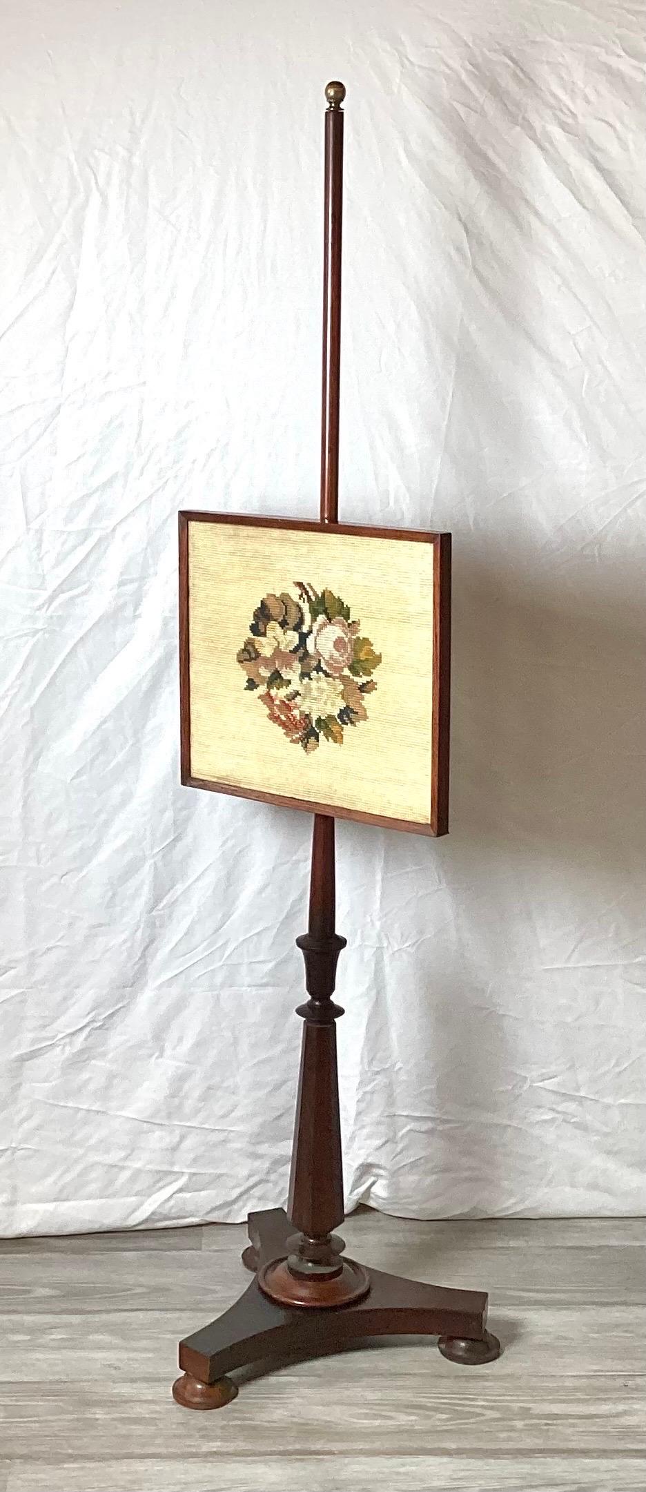 Charming antique American fire pole screen with hand made wool needlepoint panel. The slender pole with adjustable panel supported by a tripod plinth base.
