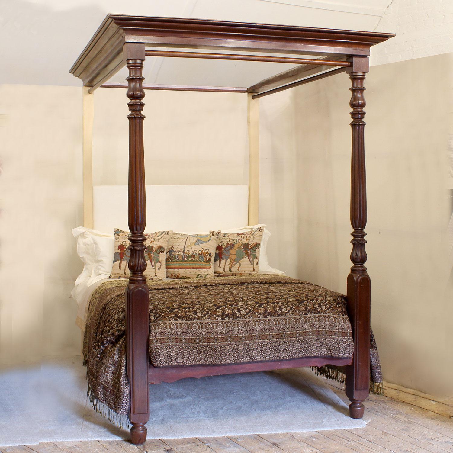 An early Victorian mahogany four poster bed with fine front posts and corniced canopy with hanging rails. This four poster bed is almost entirely original from the mid-Nineteenth Century and is an exceptional piece. 
The upholstered back board can