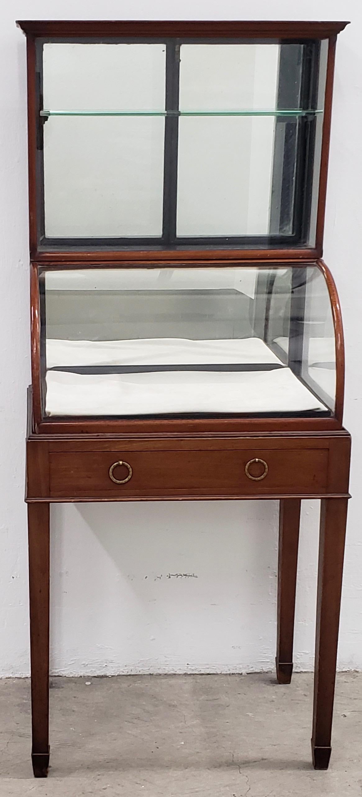Antique mahogany framed display cabinet with drawer and removable tray

Gorgeous display cabinet with drawer, mirrored backing, curved glass front, removable jewelry tray and access doors from the back. There are a few small pieces of trim