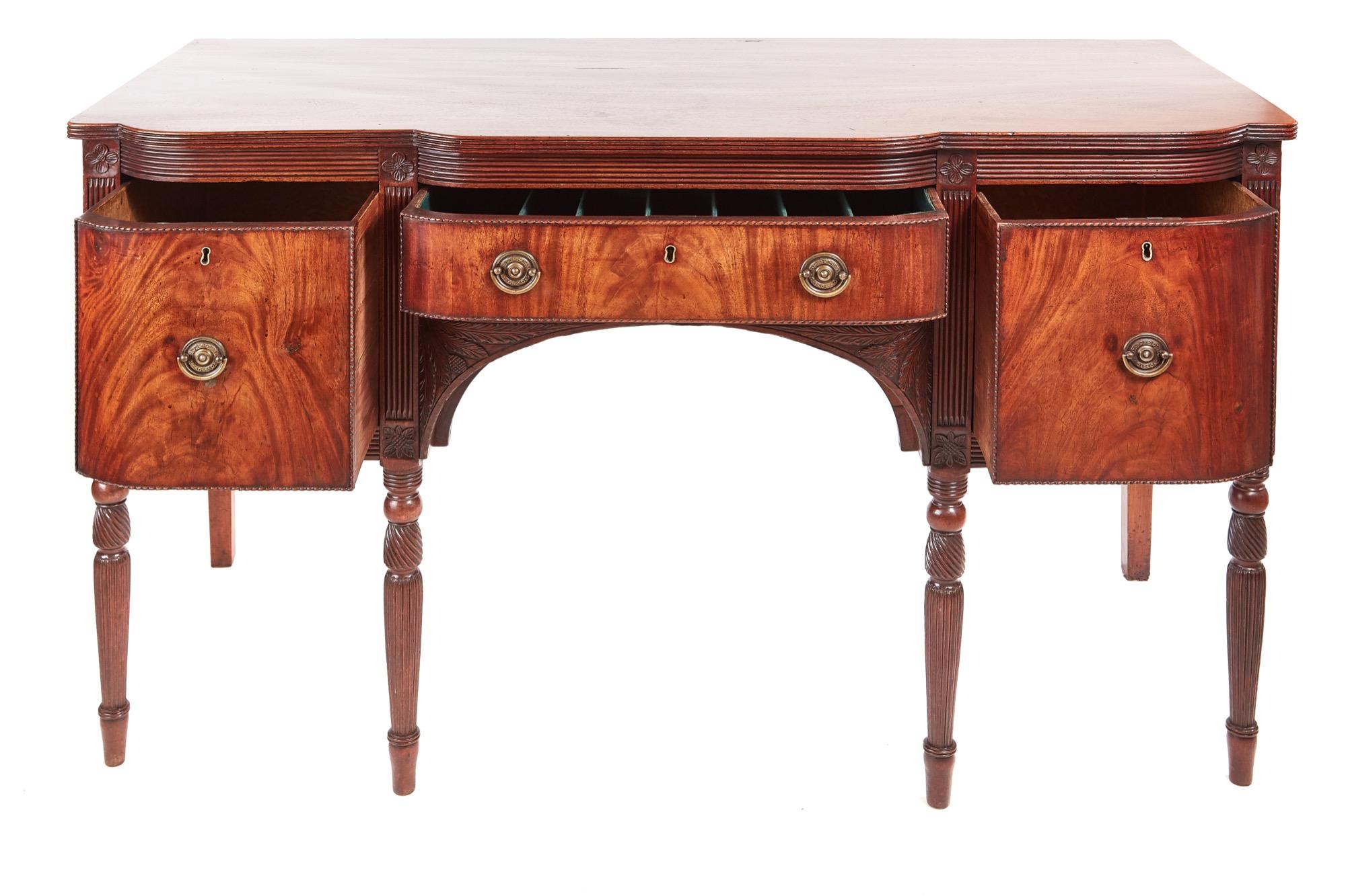 Quality mahogany Georgian antique sideboard with a lovely mahogany top having a d-shaped reeded edge. It has two shaped drawers flanking a d-shaped central drawer all with original brass handles. It has a delightful thistle carving to the central