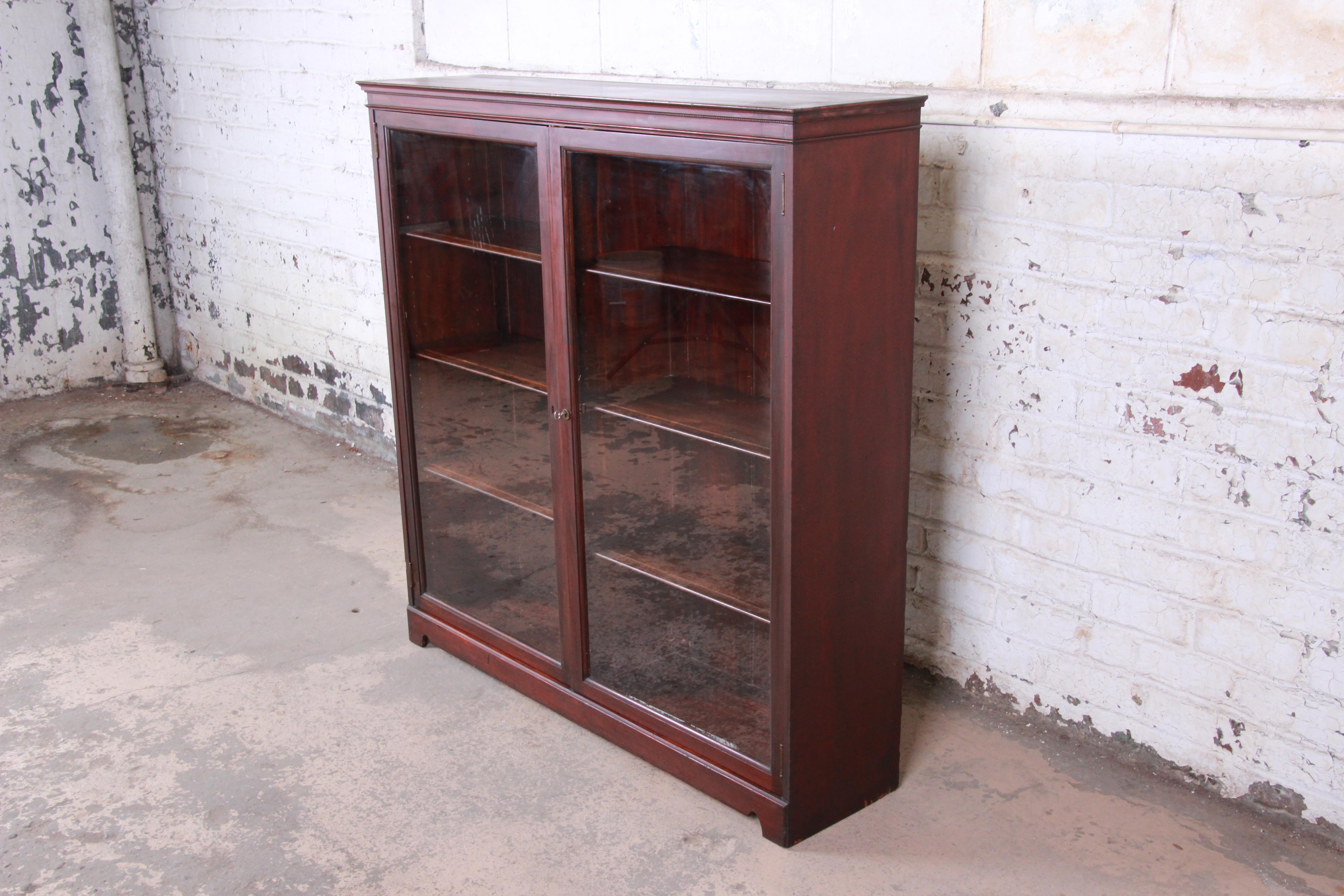 A gorgeous antique mahogany glass front double bookcase

USA, circa 1900

Shelves are adjustable. Doors lock, and key is included.

Measures: 53