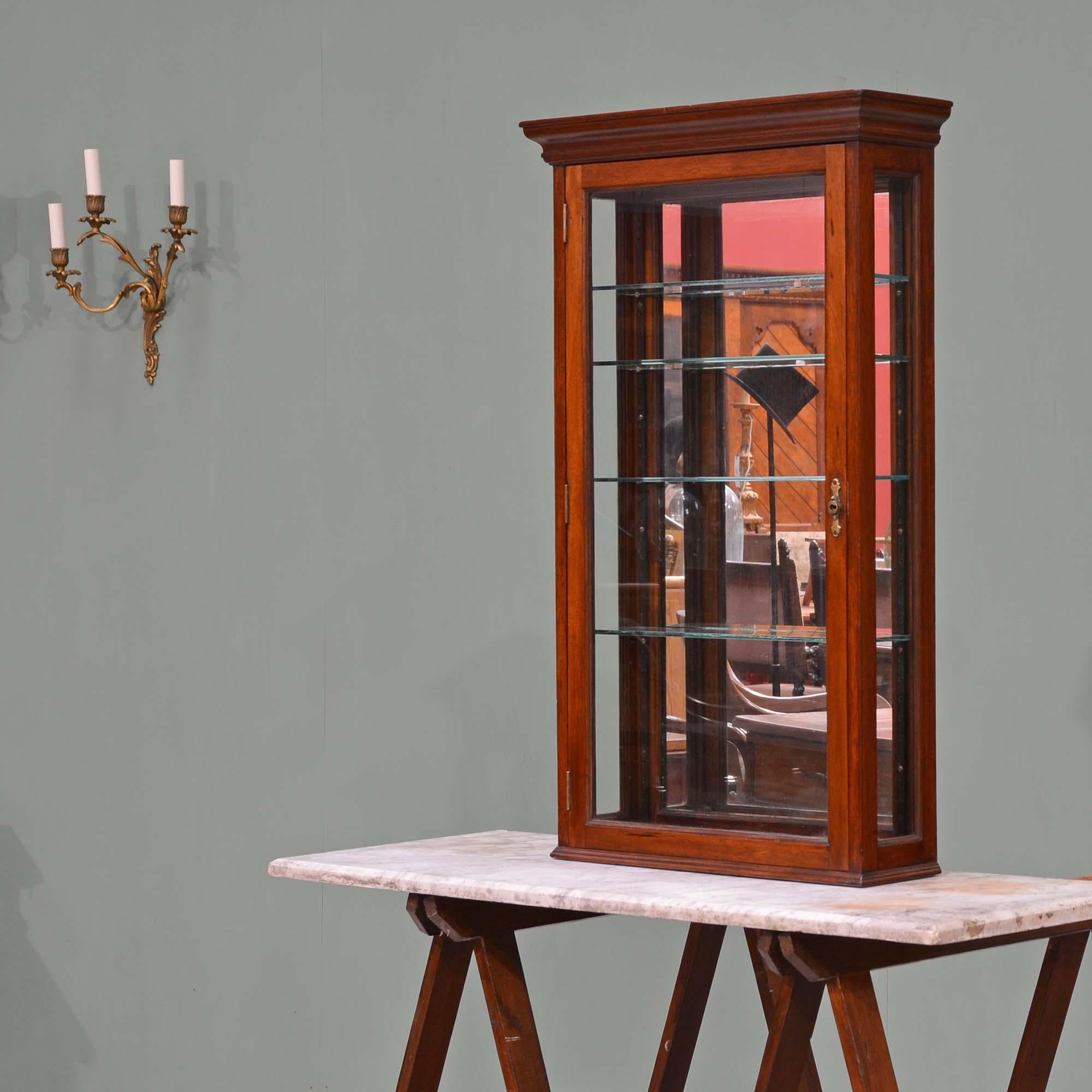 Mahogany glazed mirror backed hanging shop display cabinet
The moulded cornice over glazed door which opens to an interior with four adjustable glass display shelves and mirrored back, the sides are also glazed. The interior accessed by a removable