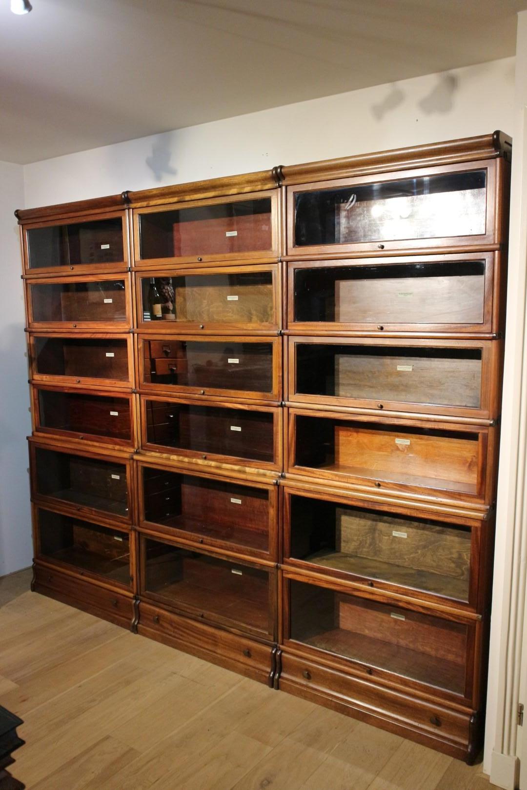 Antique mahogany Globe Wernicke bookcase in good condition. The cabinet consists of 18 stackable parts. Varying in depth and height. There are drawers in the feet. 

Origin: England
Period: Approx. 1900
Size: 260cm x 29/26cm x height 218cm.