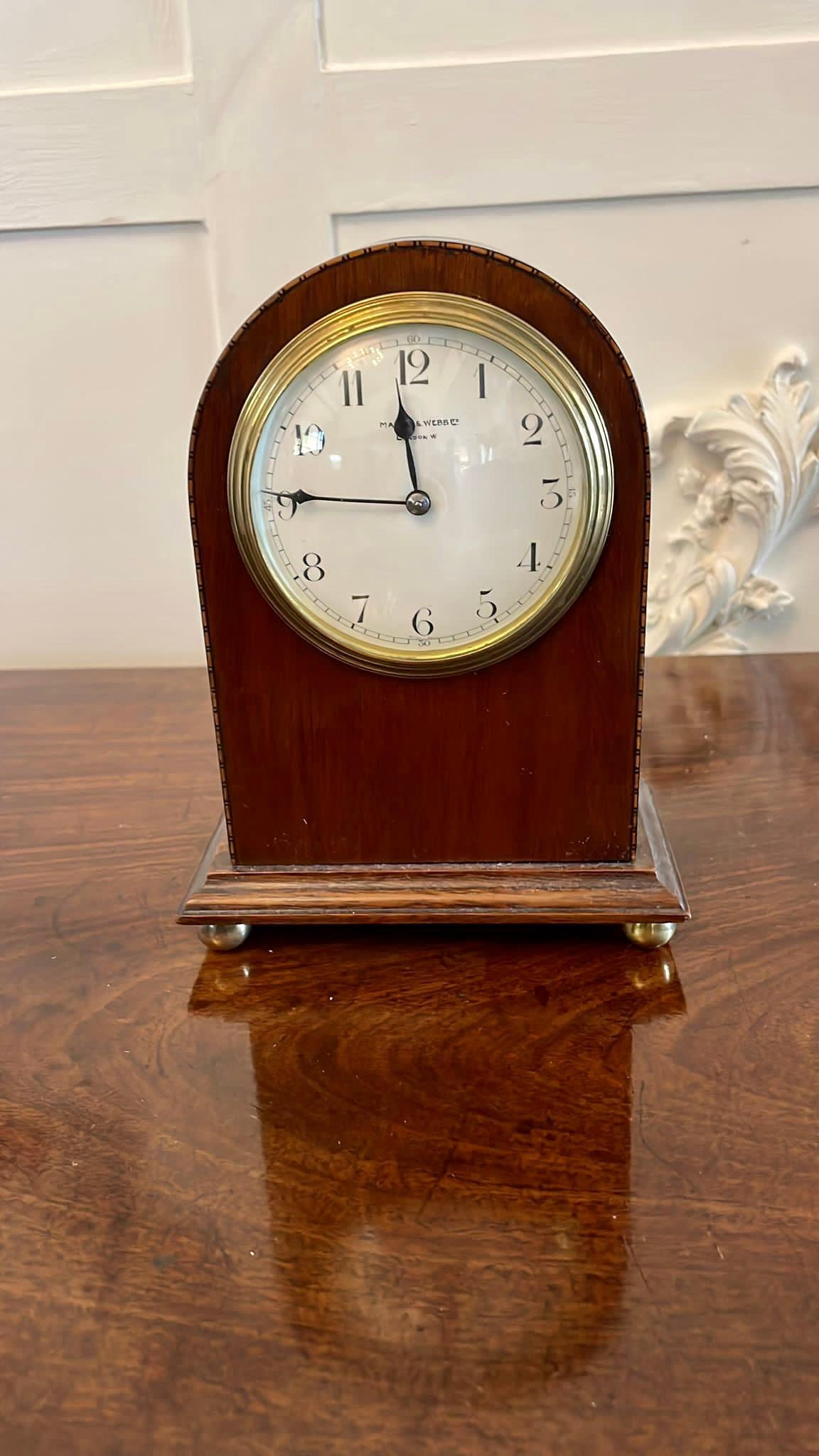 Antique mahogany inlaid mantle clock by Mappin & Webb holders of Royal Warrants to British monarchs since 1897 having a dome top case with pretty chequered inlay, porcelain face with original hands and eight day movement with original brass bezel