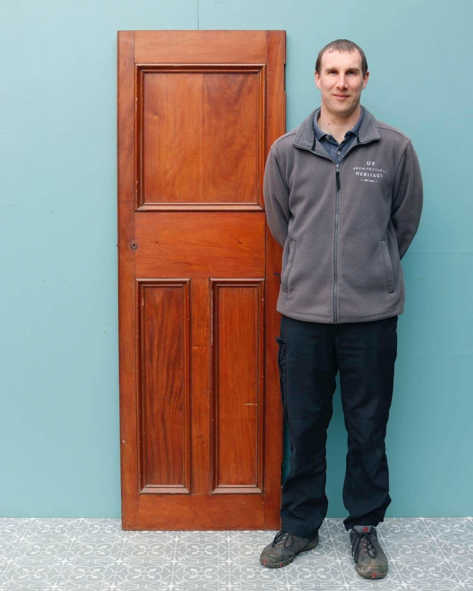 A mahogany antique internal door salvaged from a Victorian office building in Chester, England. This smart door has a narrow profile outlined with a large panel to the top and a pair of vertical panels to the base in classic Victorian style. There